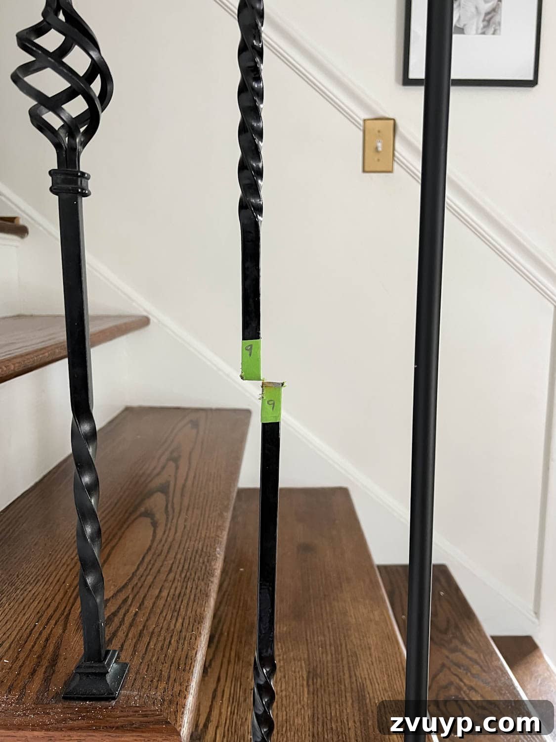 DIY Stair Spindle Swap For A Modern Makeover 9 Painter's tape clearly marking areas for cutting old stair balusters before removal