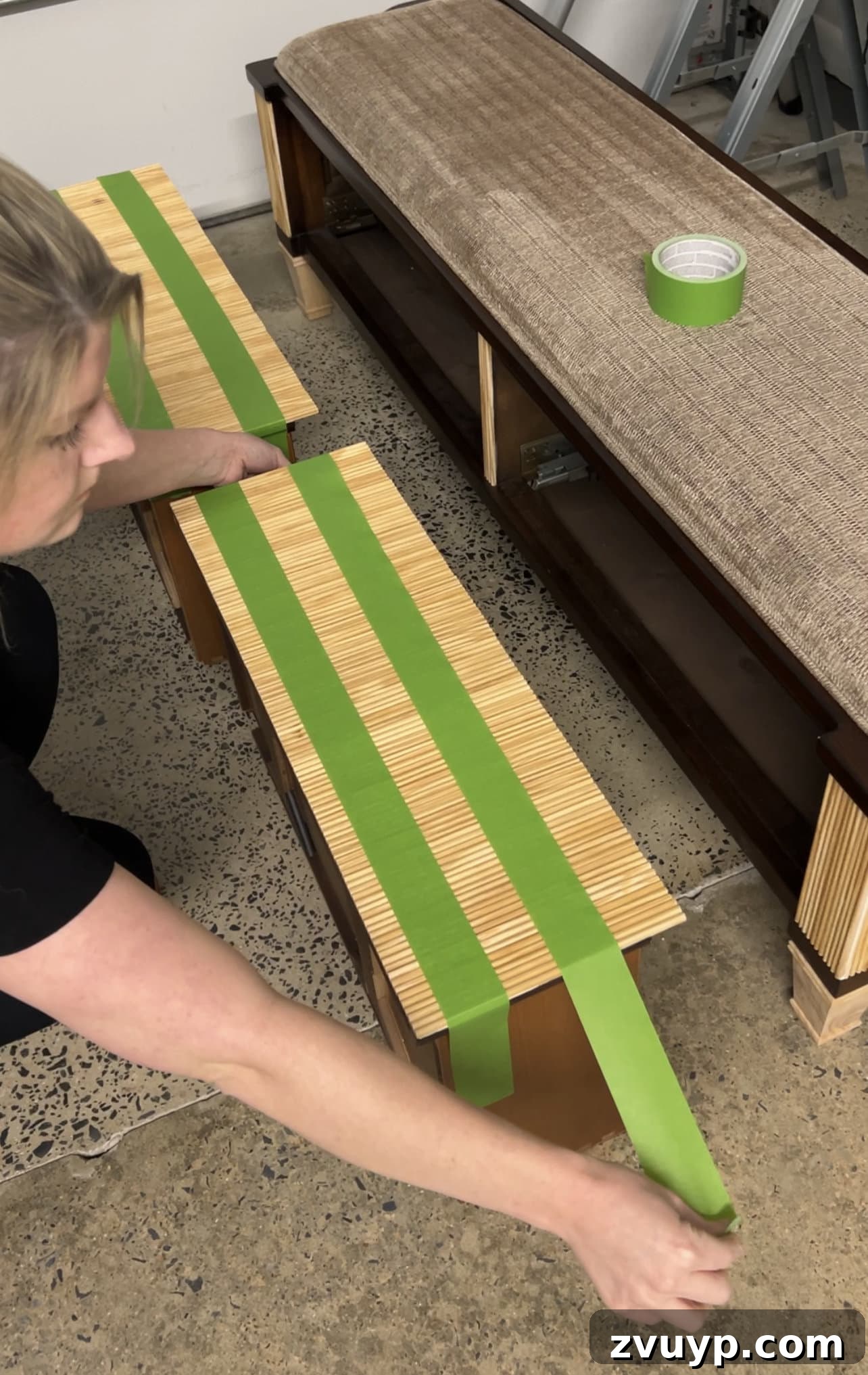 From Bland to Grand The Reeded Shoe Bench Makeover 14 Reeded molding being carefully attached to the drawer fronts of the bench using construction adhesive, creating a textured surface.