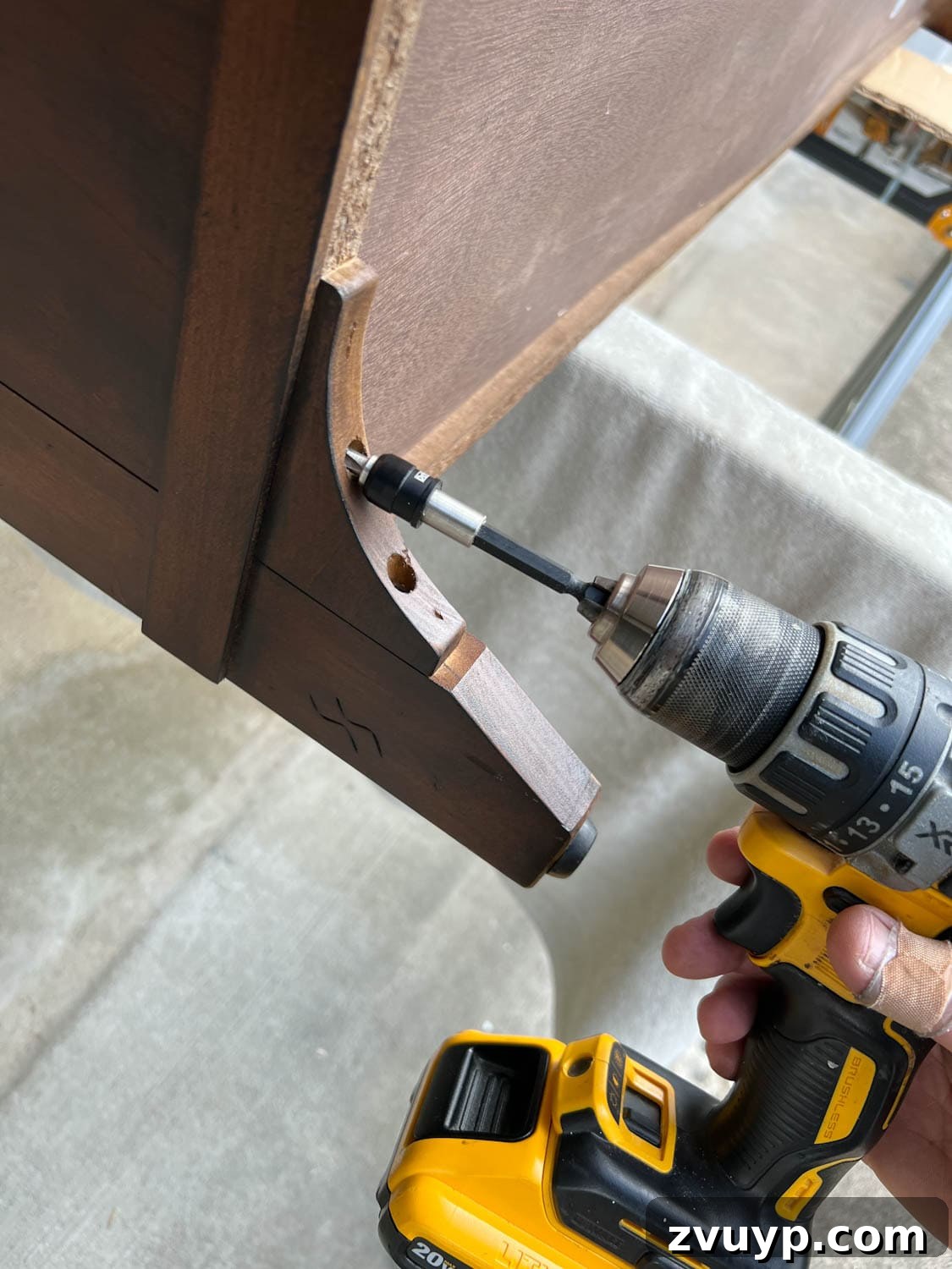 From Bland to Grand The Reeded Shoe Bench Makeover 6 Close-up shot of screws being removed from old furniture legs, preparing the bench for new, stylish replacements.