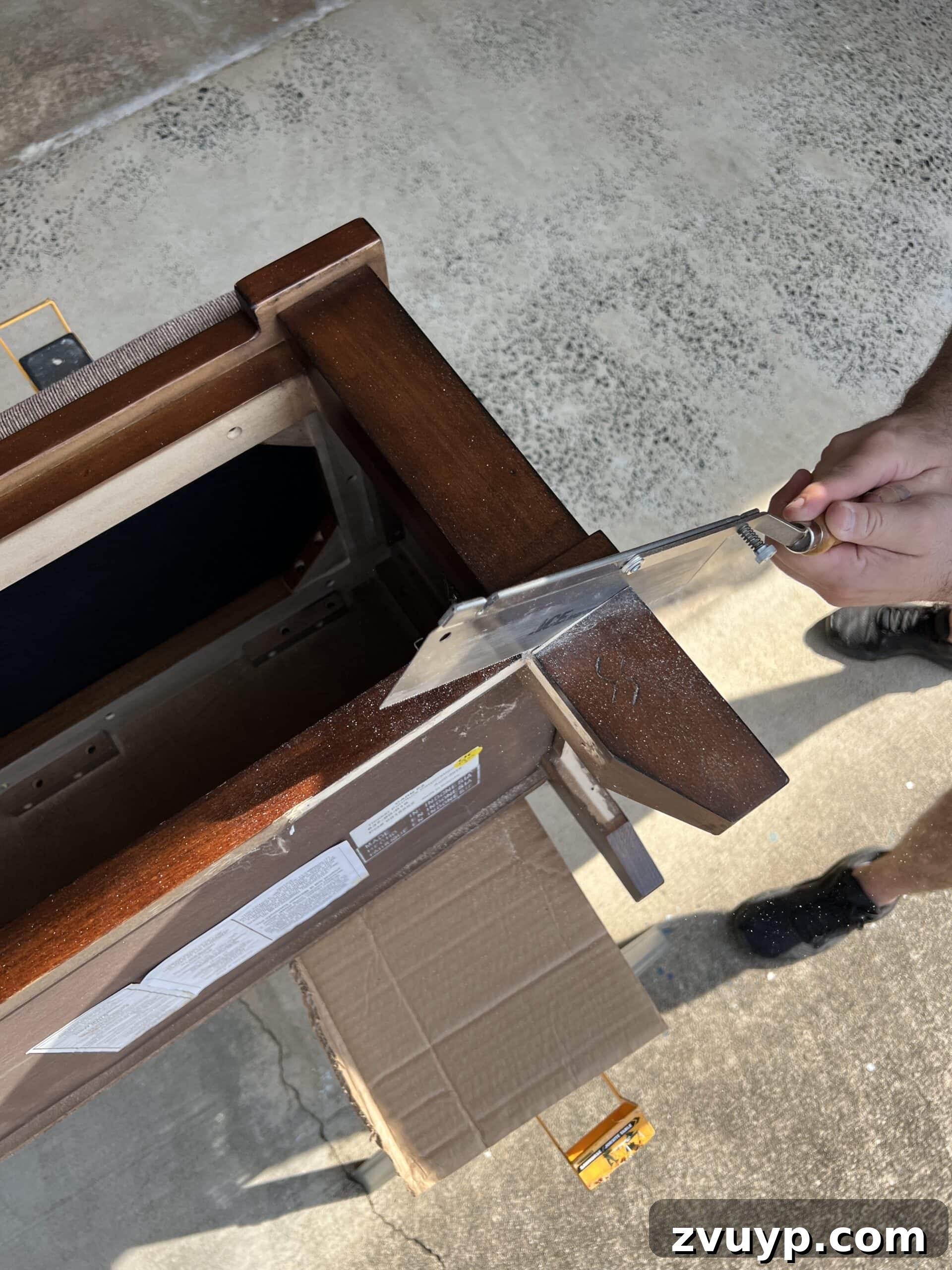From Bland to Grand The Reeded Shoe Bench Makeover 7 A hand saw being used to carefully cut off old, chunky furniture legs from the bench, ensuring a precise and controlled cut for replacement.