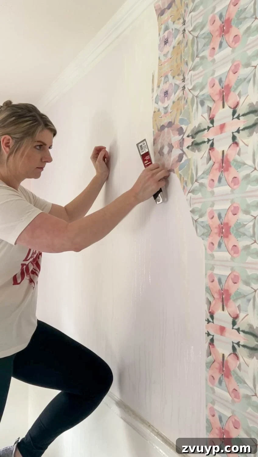 Mastering Wallpaper Removal: 3 Tried and True Methods 14 Using a putty knife to loosen wallpaper after applying vinegar solution