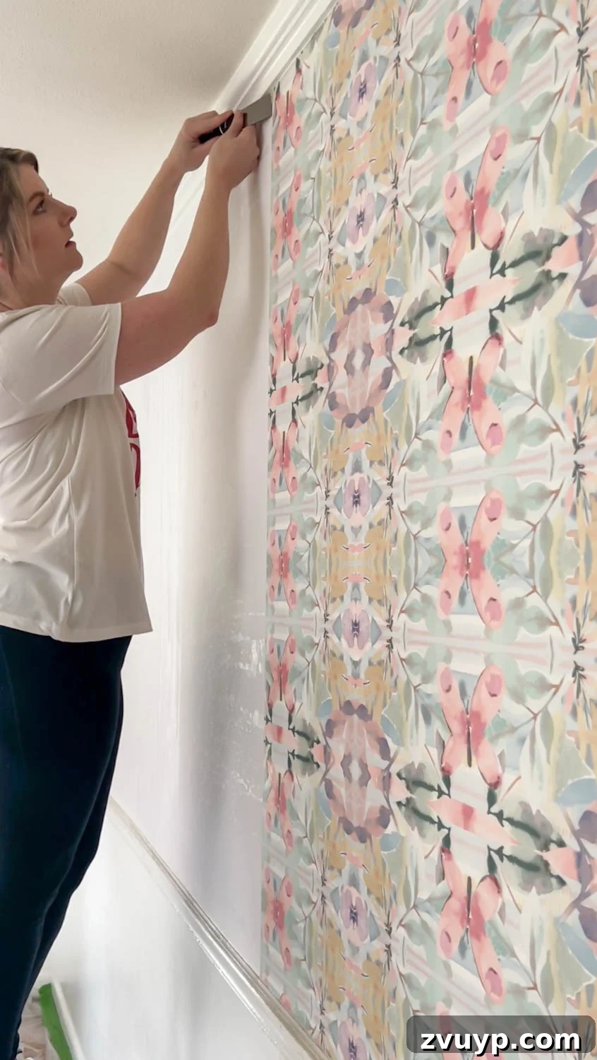 Mastering Wallpaper Removal: 3 Tried and True Methods 9 Using a putty knife to loosen wallpaper edges, testing for easy removal
