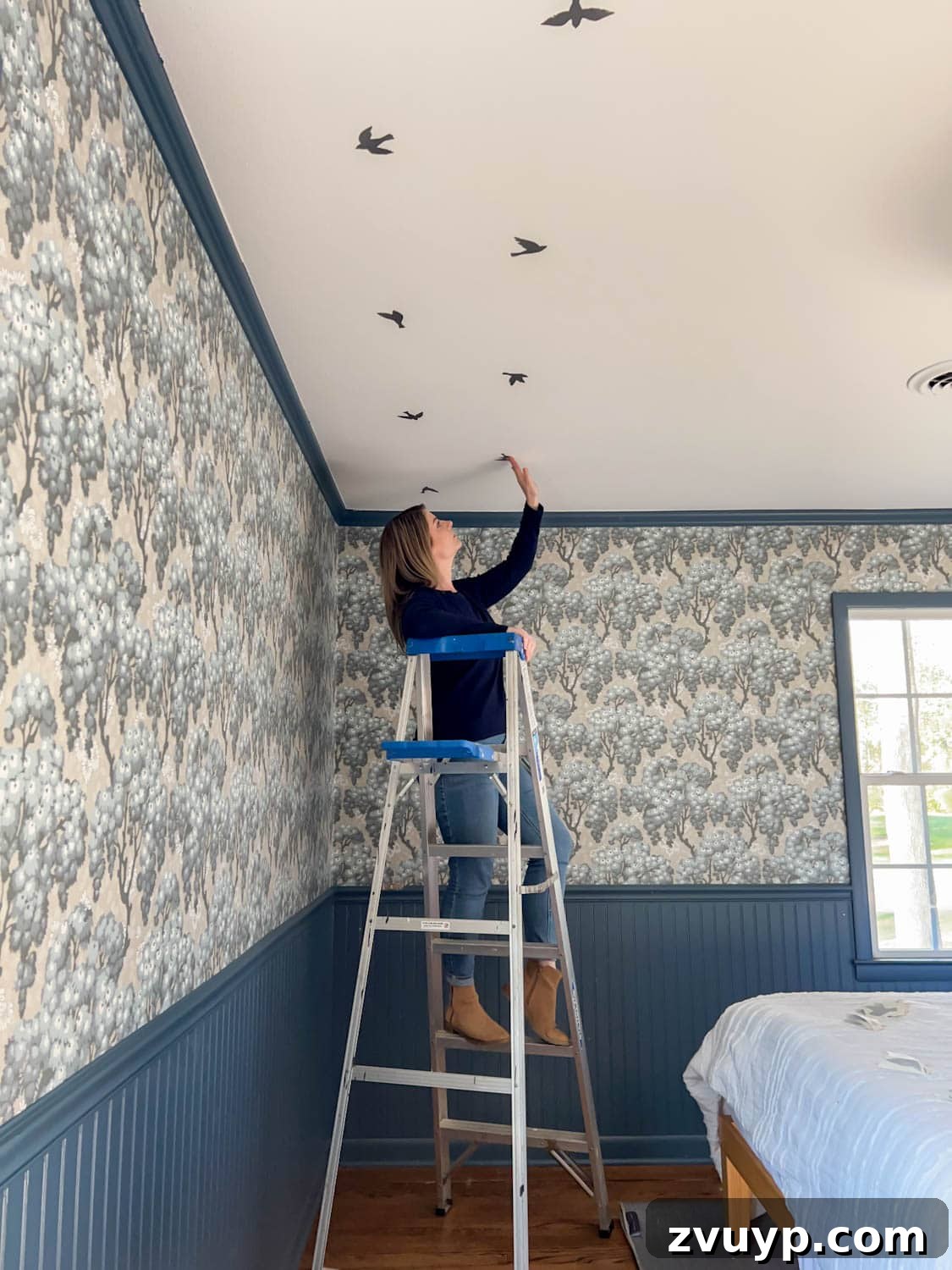 DIY Faux Block Print Ceiling Vinyl Decal Wallpaper 3 Applying bird vinyl decals in a precise block print pattern to create faux ceiling wallpaper, showing the process of careful placement.