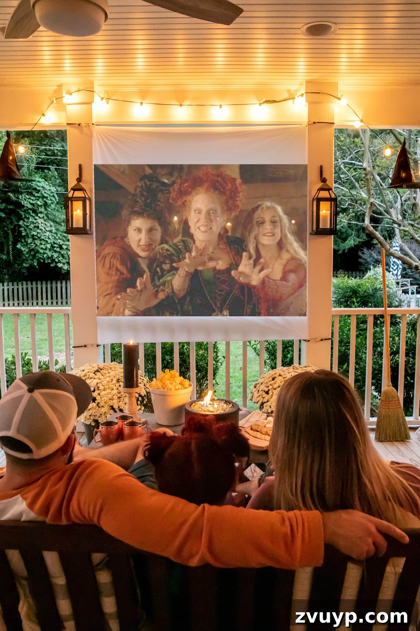 Effortless Backyard DIY: Create Your Dream Outdoor Space on a Budget 24 outdoor movie night setup on a back porch with fall decor, featuring a DIY screen and cozy ambiance