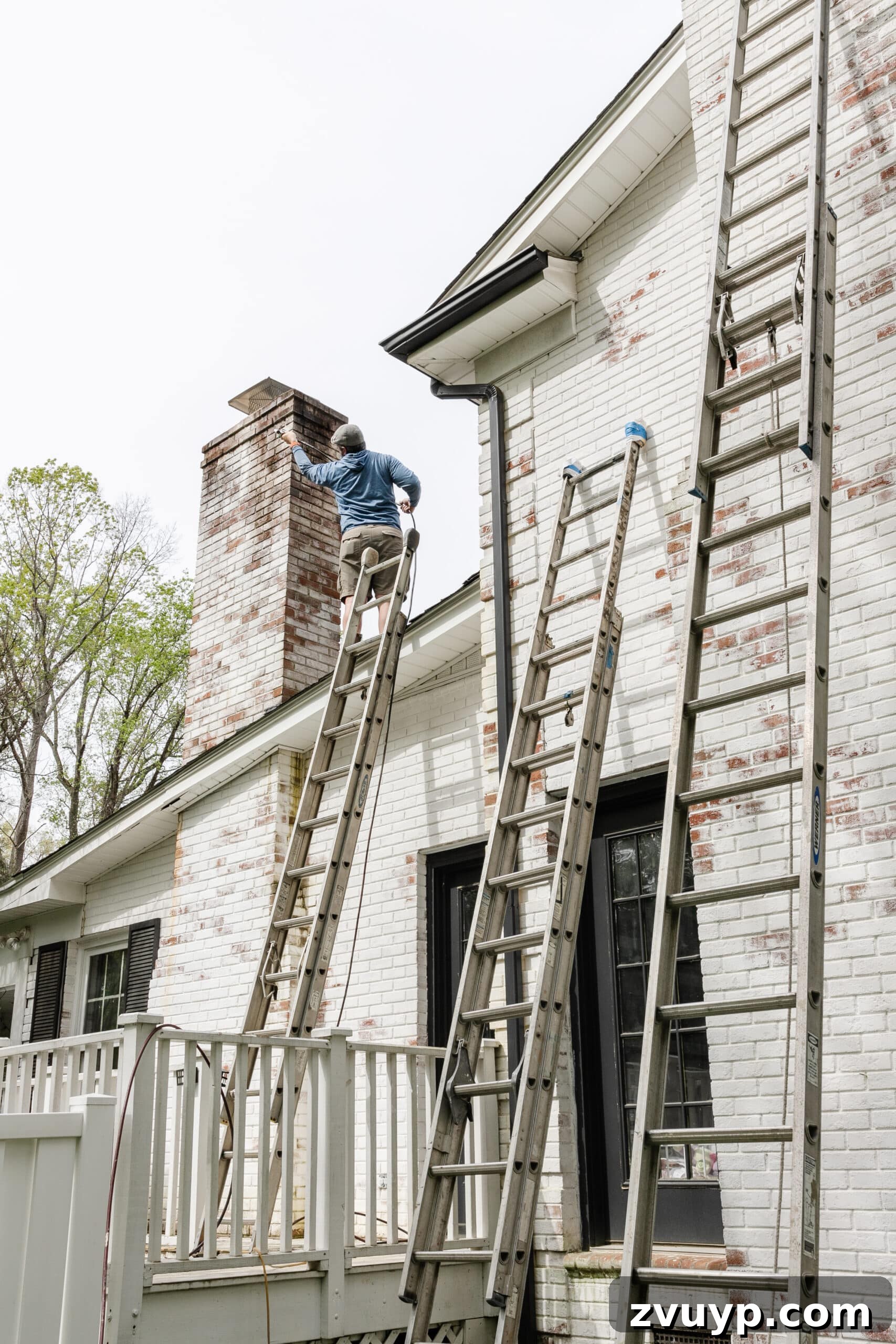 Pristine Limewashed Brick A Comprehensive Care Guide 8 Professional contractor on a ladder meticulously cleaning a limewashed chimney