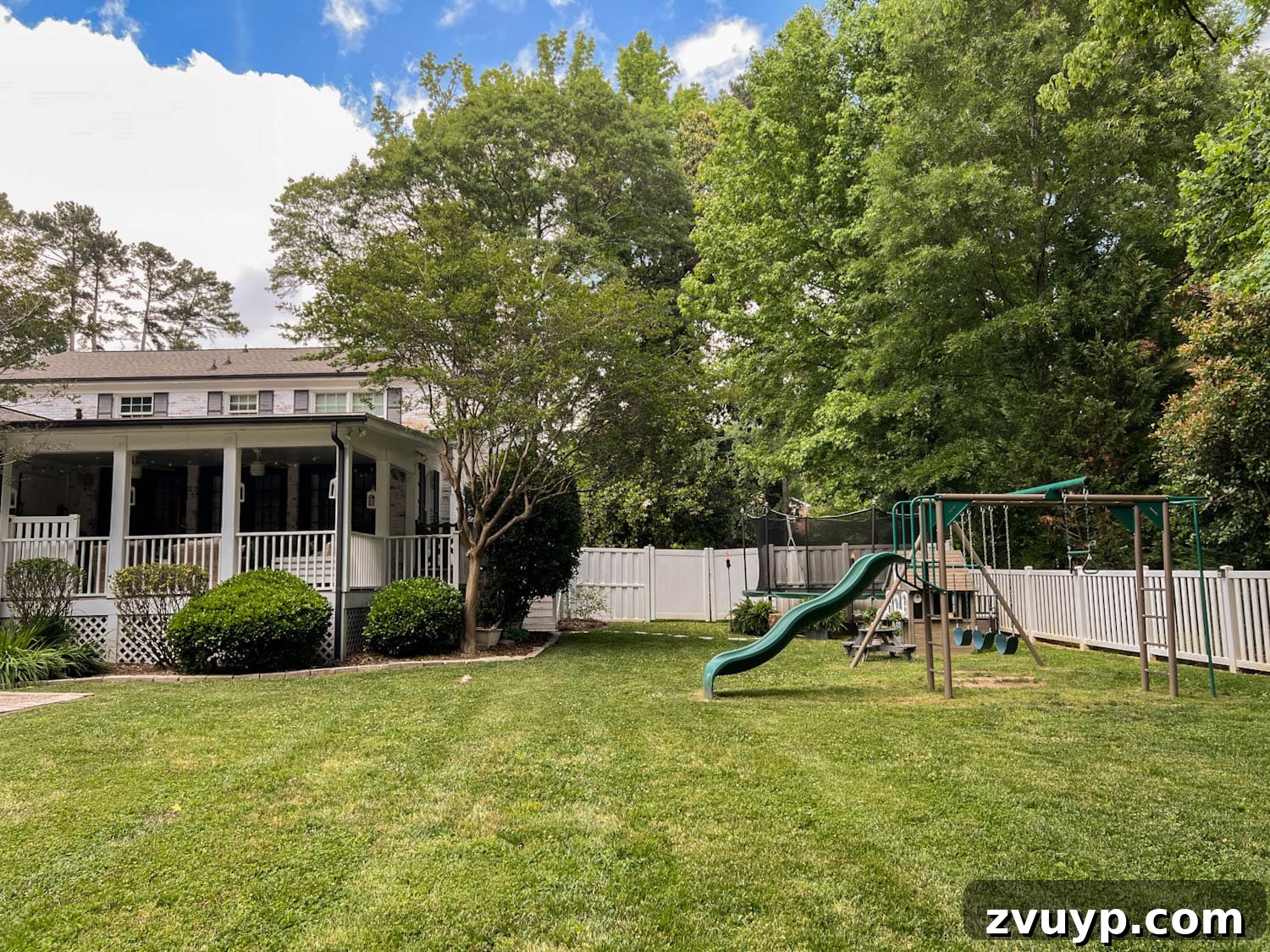 Transform Your Side Yard: 8 Play Area & Trampoline Design Ideas 2 stepping stones leading to outdoor trampoline with tree stump trampoline ladder, ferns, tiki torches, playhouse, picnic table, and swing set