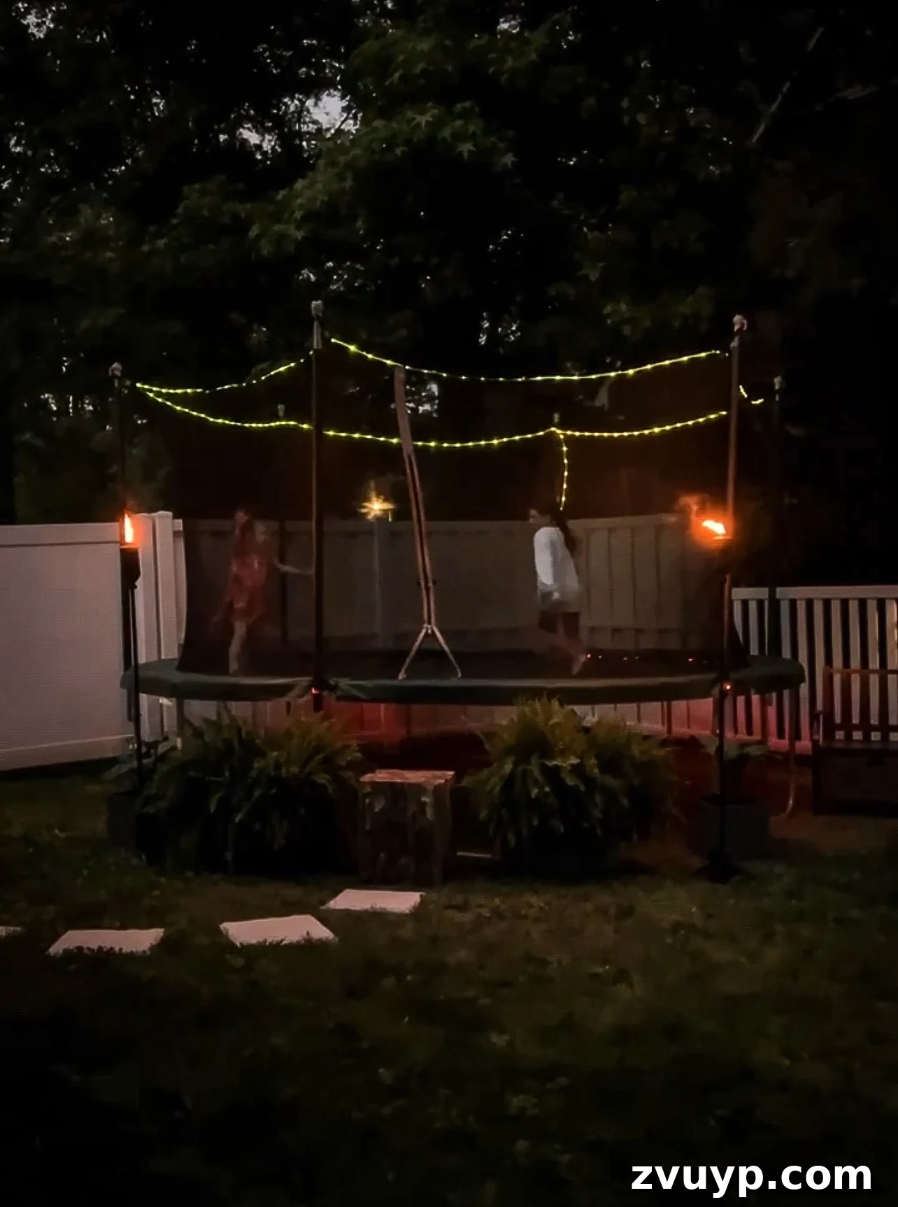 Transform Your Side Yard: 8 Play Area & Trampoline Design Ideas 13 backyard trampoline with lights at night, creating a magical glow
