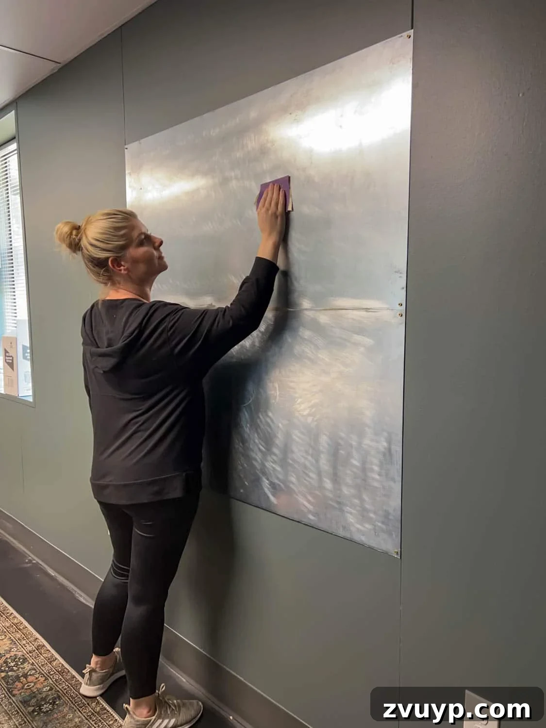 Craft Your Magnetic Wall Art Memo Board 10 sanding metal sheets on a wall to prepare for mural application as DIY art