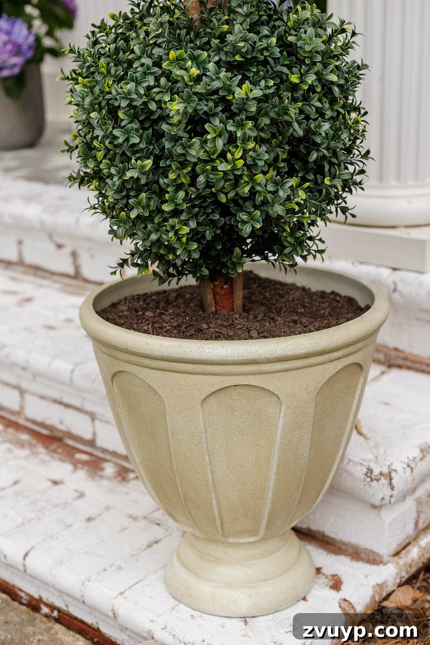 Lifelike Faux Plants for Effortless Porch Planters 10 resin urn planter on a front porch with faux topiary