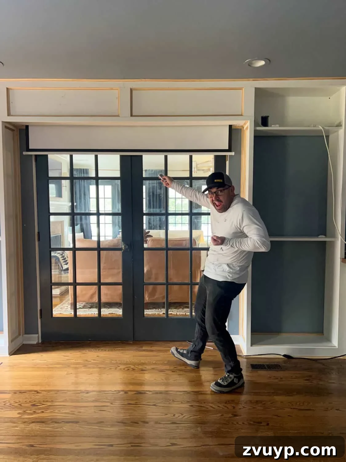 The Ultimate Hidden Projector Screen IKEA Hack 14 Retractable projector screen with remote control elegantly concealed above French doors in a finished media room