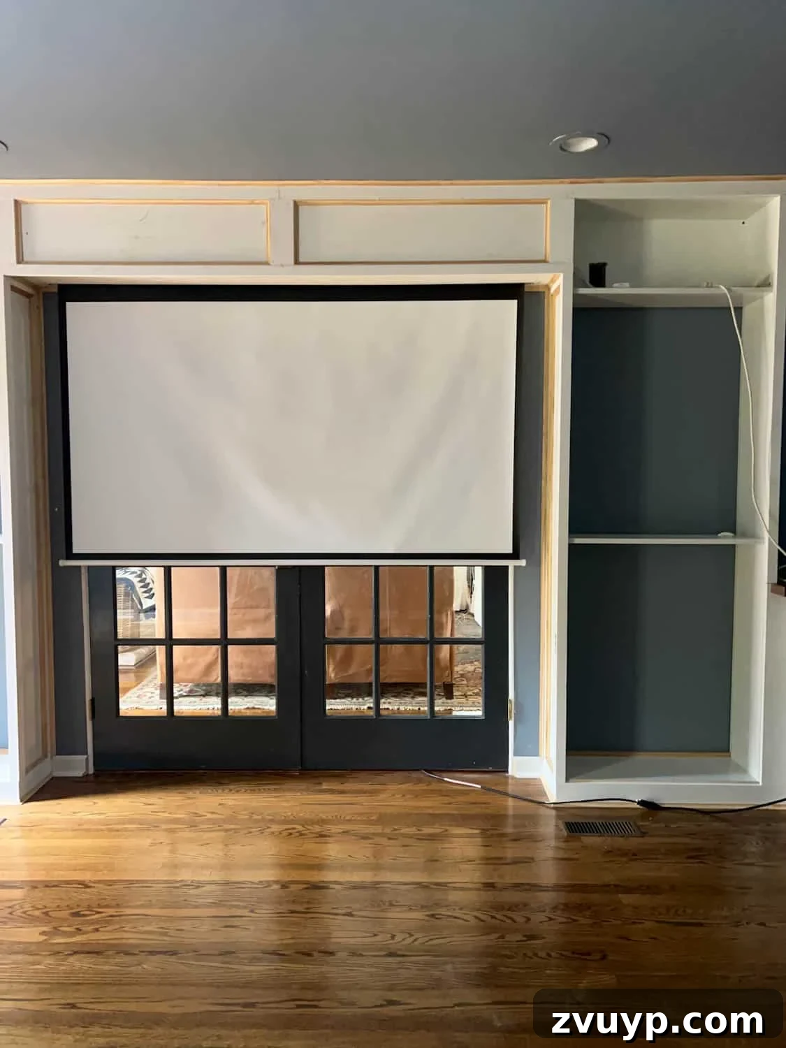 The Ultimate Hidden Projector Screen IKEA Hack 15 Concealed projector screen integrated above French doors between custom built-in bookcases