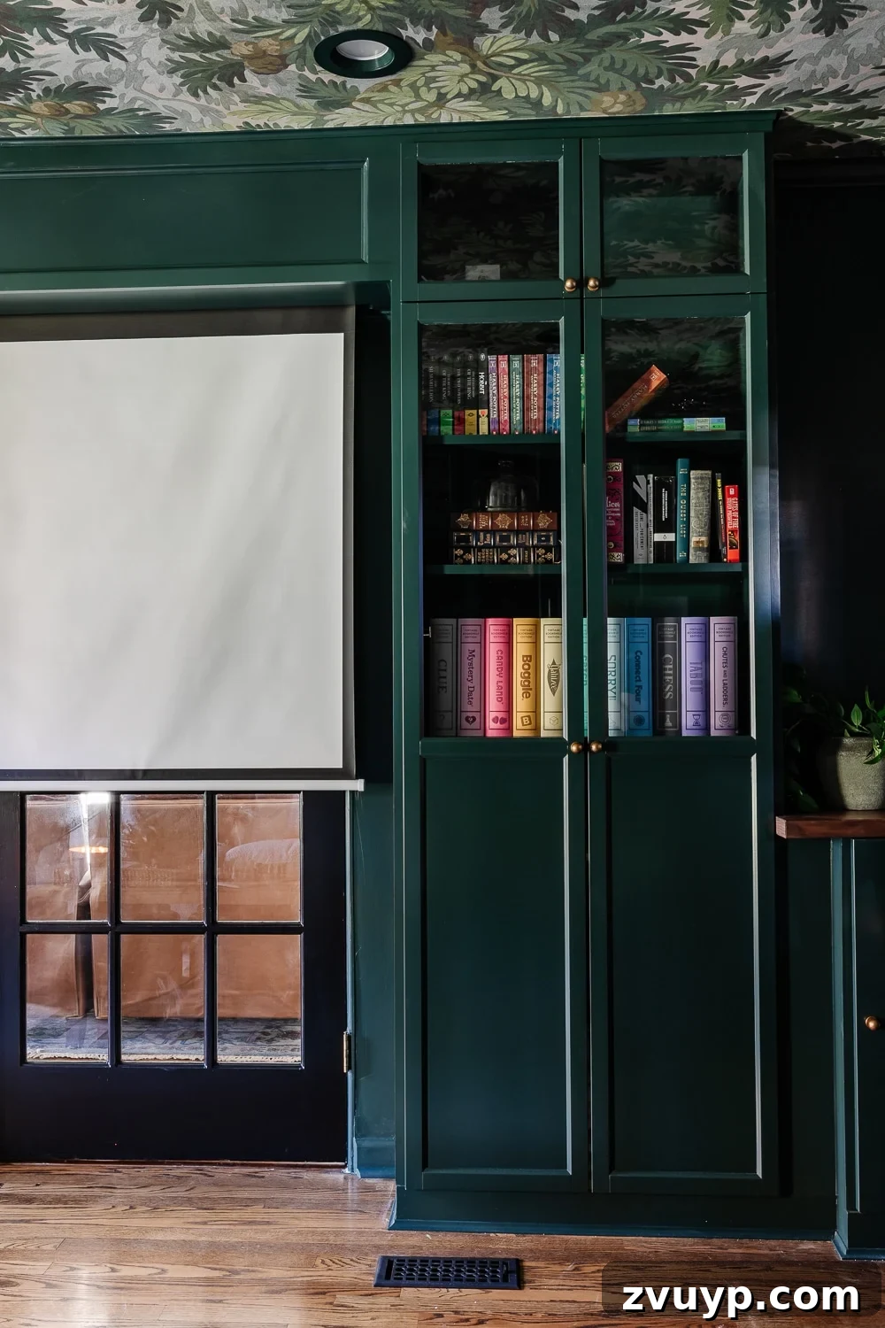 Affordable DIY Media Room Transformation 9 IKEA Billy bookcase built-in with glass-front OXBERG doors and a glimpse of the motorized movie screen setup