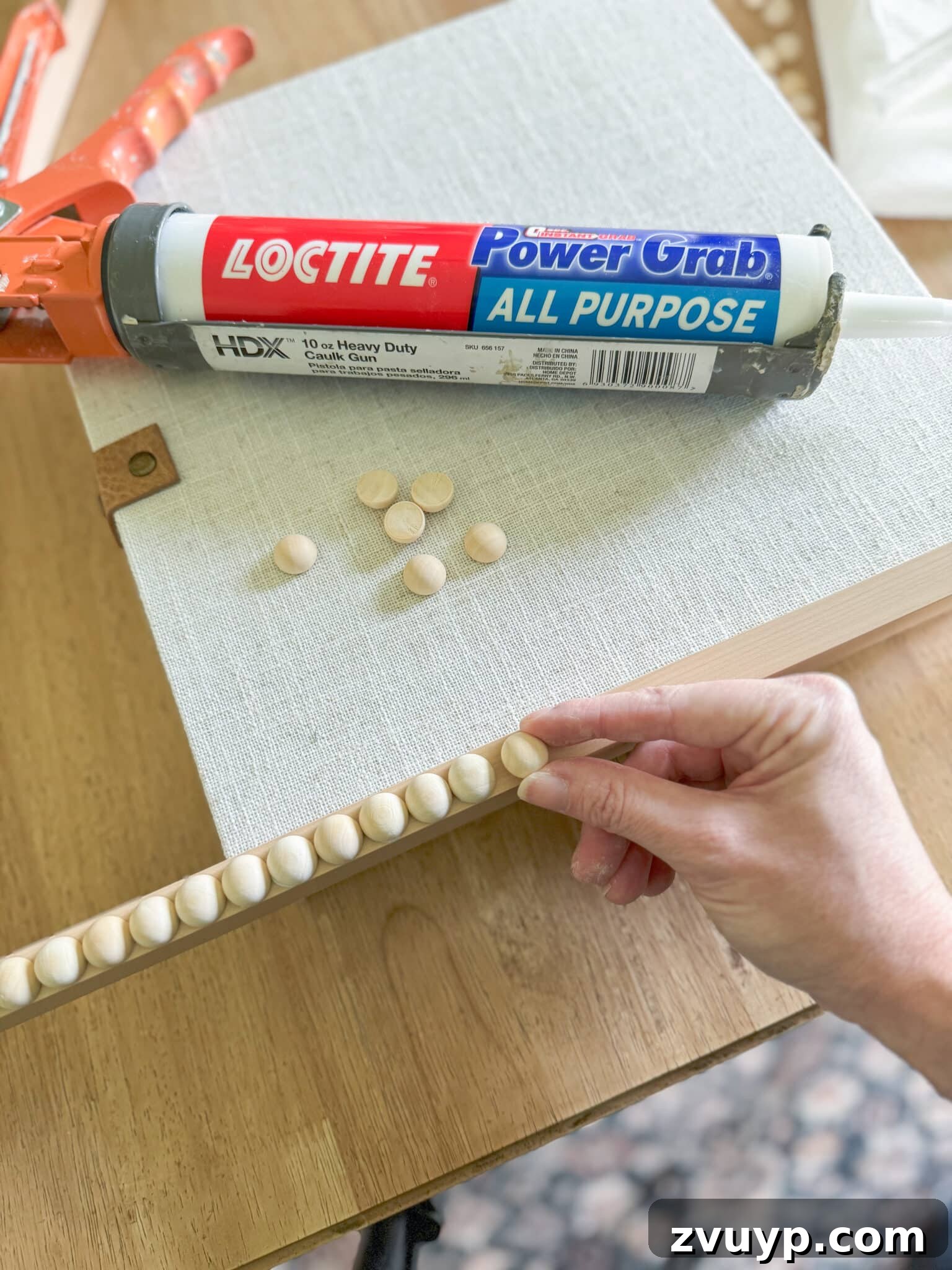 Give Your Samsung Frame TV a Bobbin Frame Makeover 5 Detailed shot of applying wooden split balls to a Samsung Frame TV bezel using a chopstick for precision