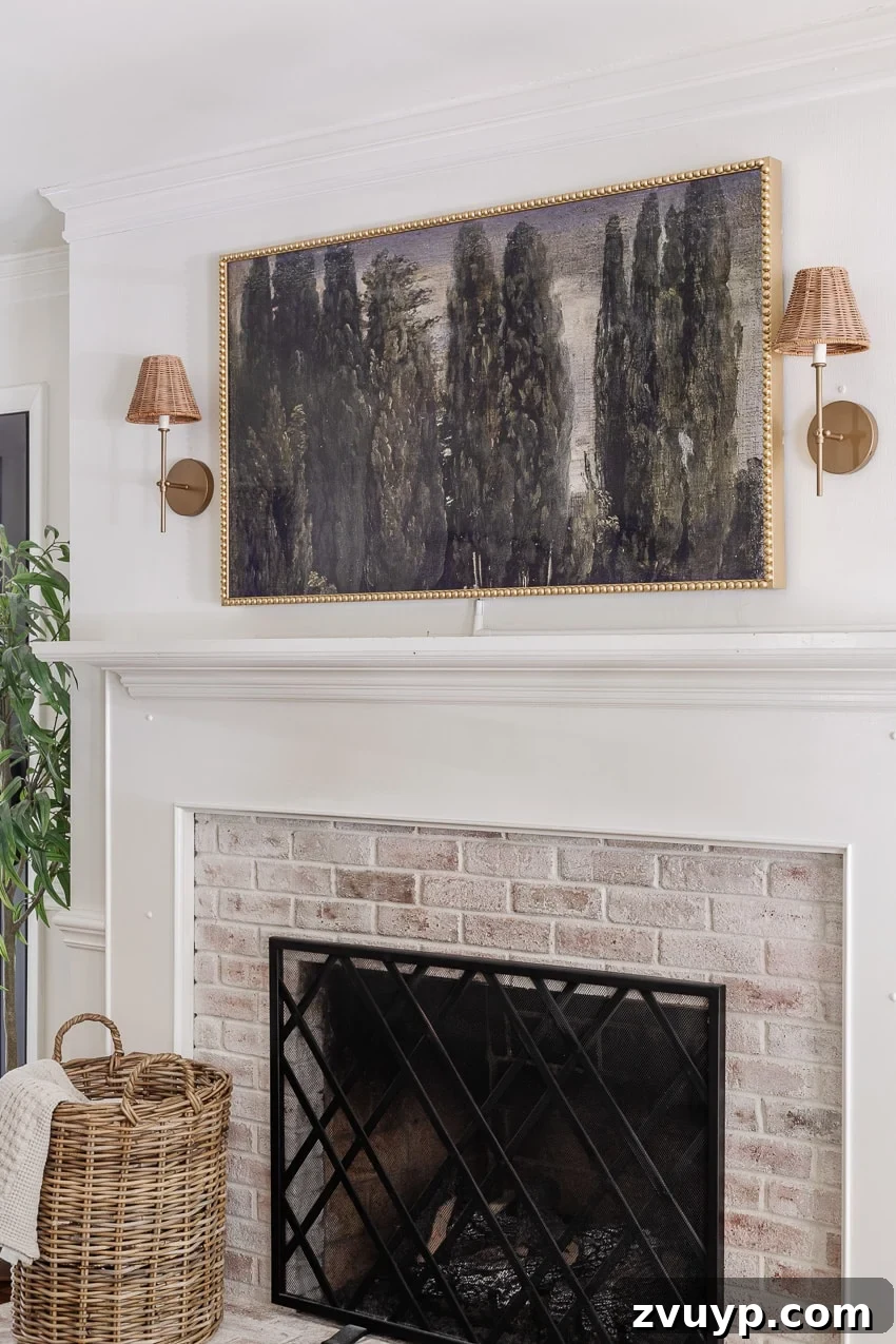 Give Your Samsung Frame TV a Bobbin Frame Makeover 8 Finished DIY bobbin frame on a Samsung Frame TV above a limewashed brick fireplace, adorned with rattan sconces, showcasing a cozy and elegant living room setting
