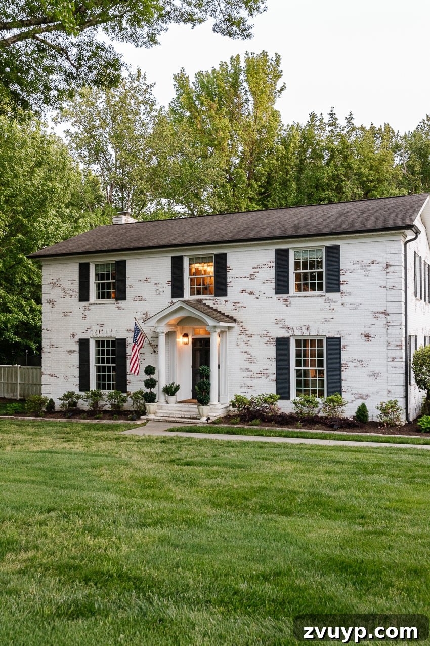From Patchy to Pristine Our One-Year Front Yard Makeover 13 white brick house with green grass in front