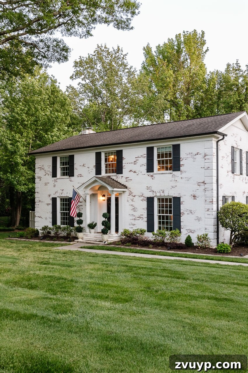 From Patchy to Pristine Our One-Year Front Yard Makeover 3 white limewashed brick colonial house with green lawn