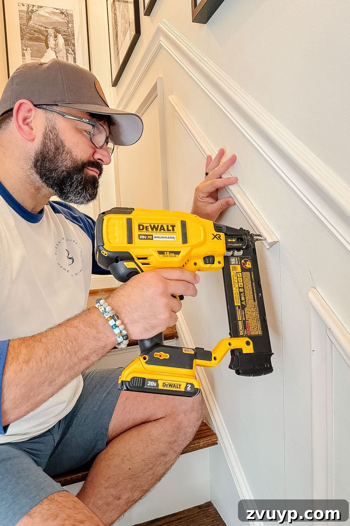Transform Your Stairs: Effortless DIY Wainscoting Guide 14 Nailing angled molding precisely on stairs for wainscoting