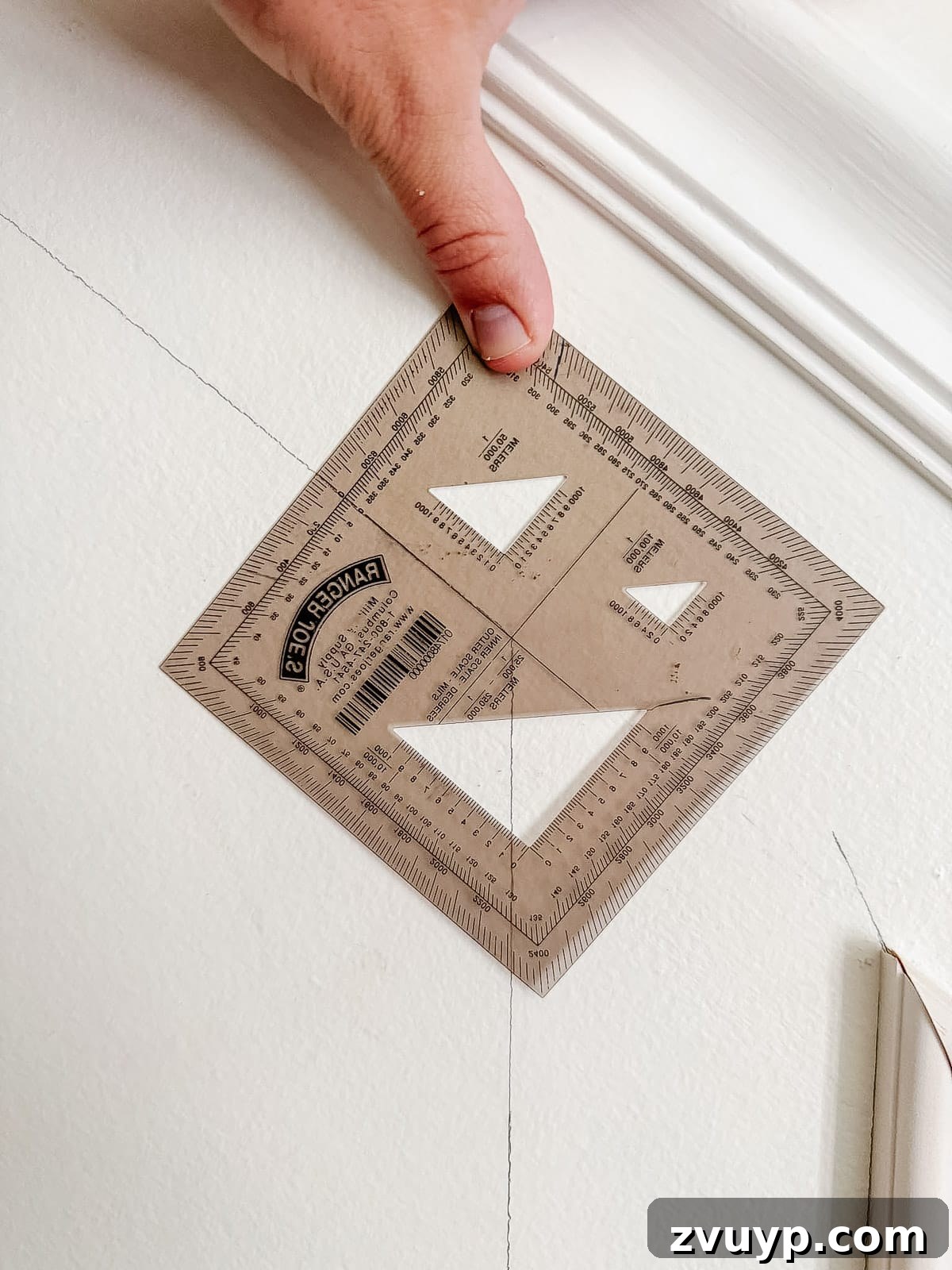 Transform Your Stairs: Effortless DIY Wainscoting Guide 5 Using a military protractor to find exact molding angles on stairs