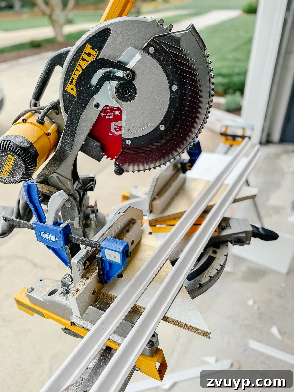 Transform Your Stairs: Effortless DIY Wainscoting Guide 8 Picture frame molding positioned on a miter saw with a custom jig guide