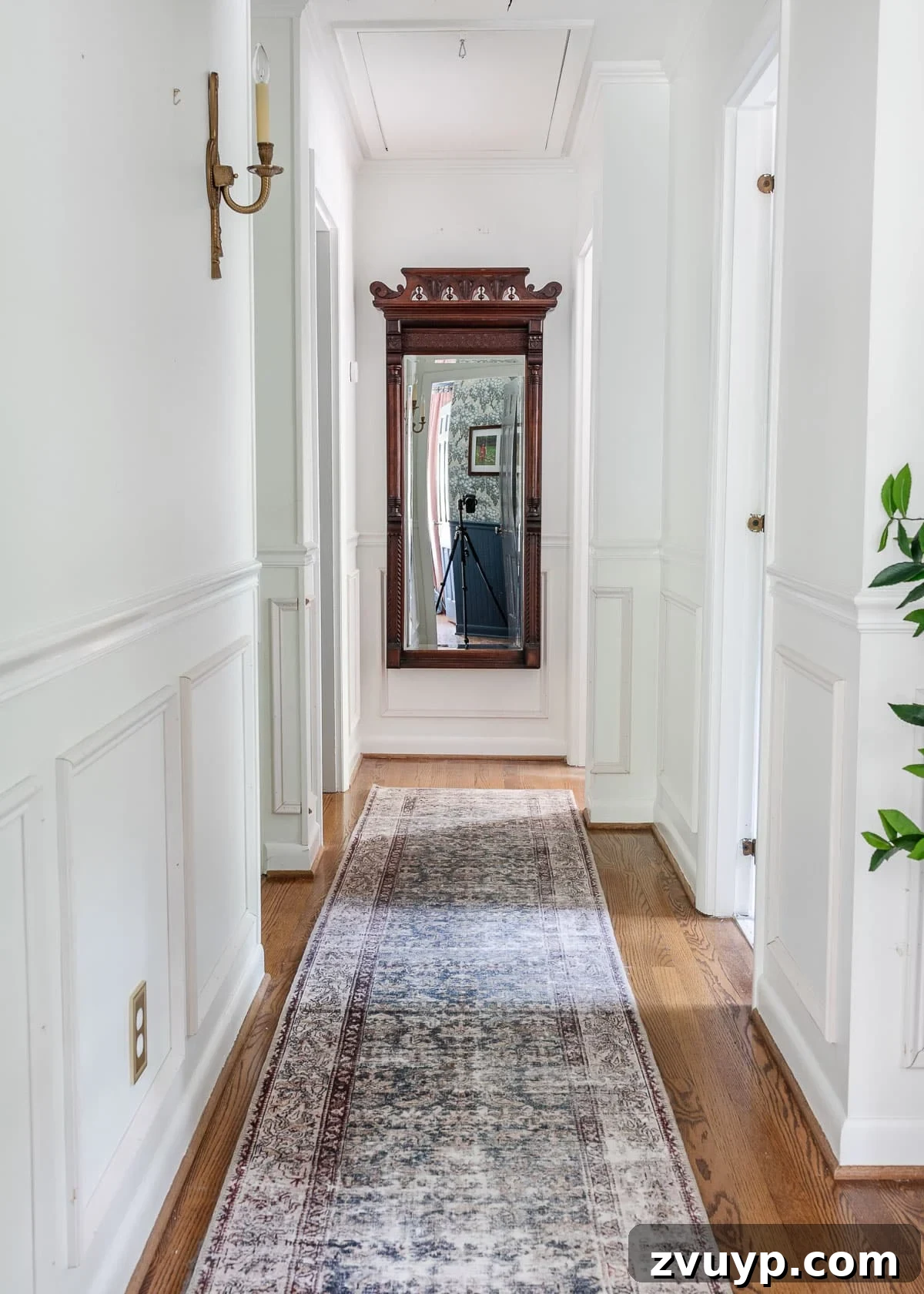 Your Essential Guide to Online Antique Shopping: Furniture and Home Decor Finds 3 White hallway featuring a large, ornate antique mirror, reflecting light and adding depth