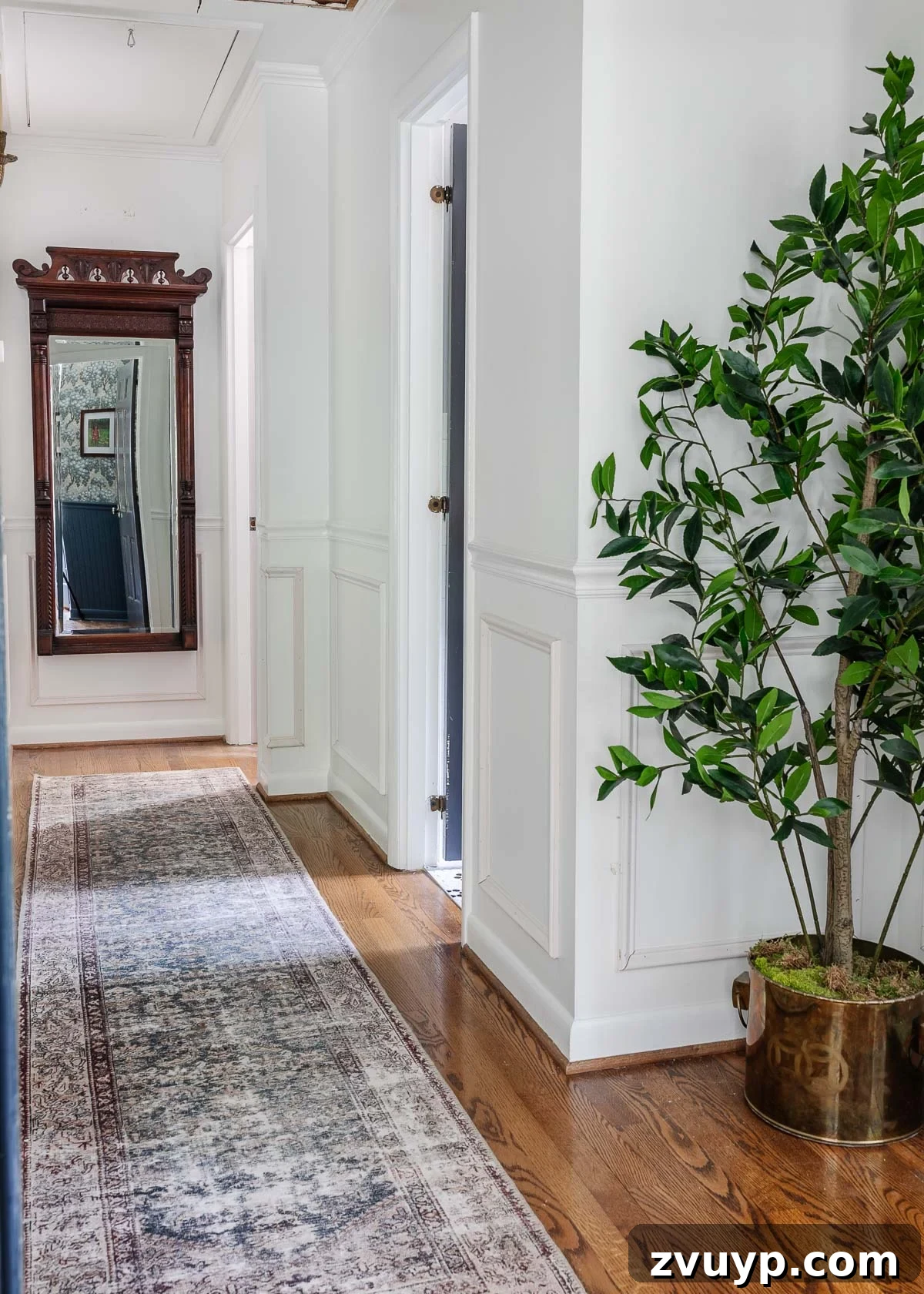 Your Essential Guide to Online Antique Shopping: Furniture and Home Decor Finds 9 Bright white hallway featuring a large, ornate antique mirror, reflecting natural light and enhancing the sense of space with classic elegance