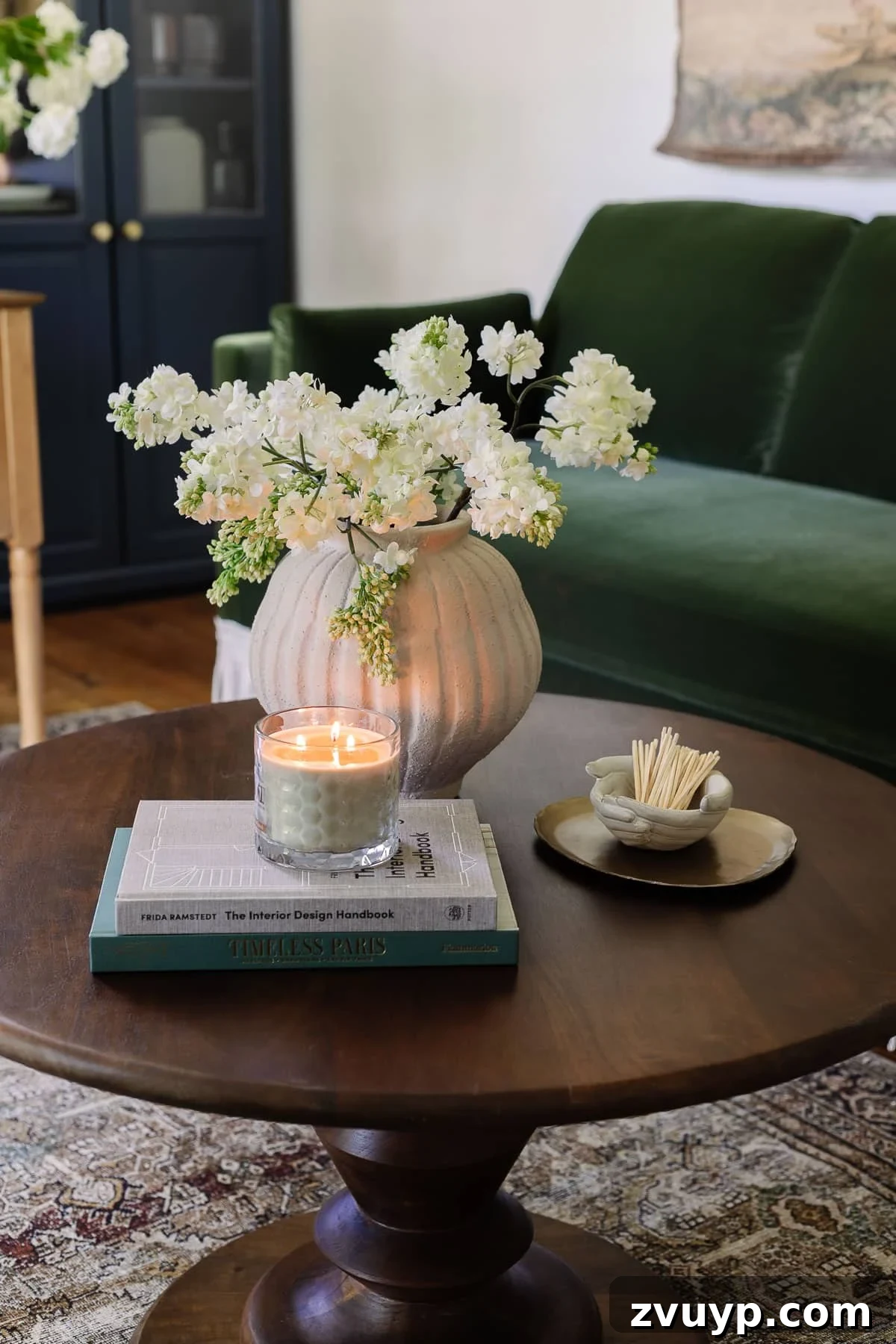 Power Up Your Productivity: Smart Home Office Layouts 11 Charming coffee table decor featuring a vase of fresh flowers, inspiring coffee table books, a calming candle, a decorative tray, and a unique bowl of matches.