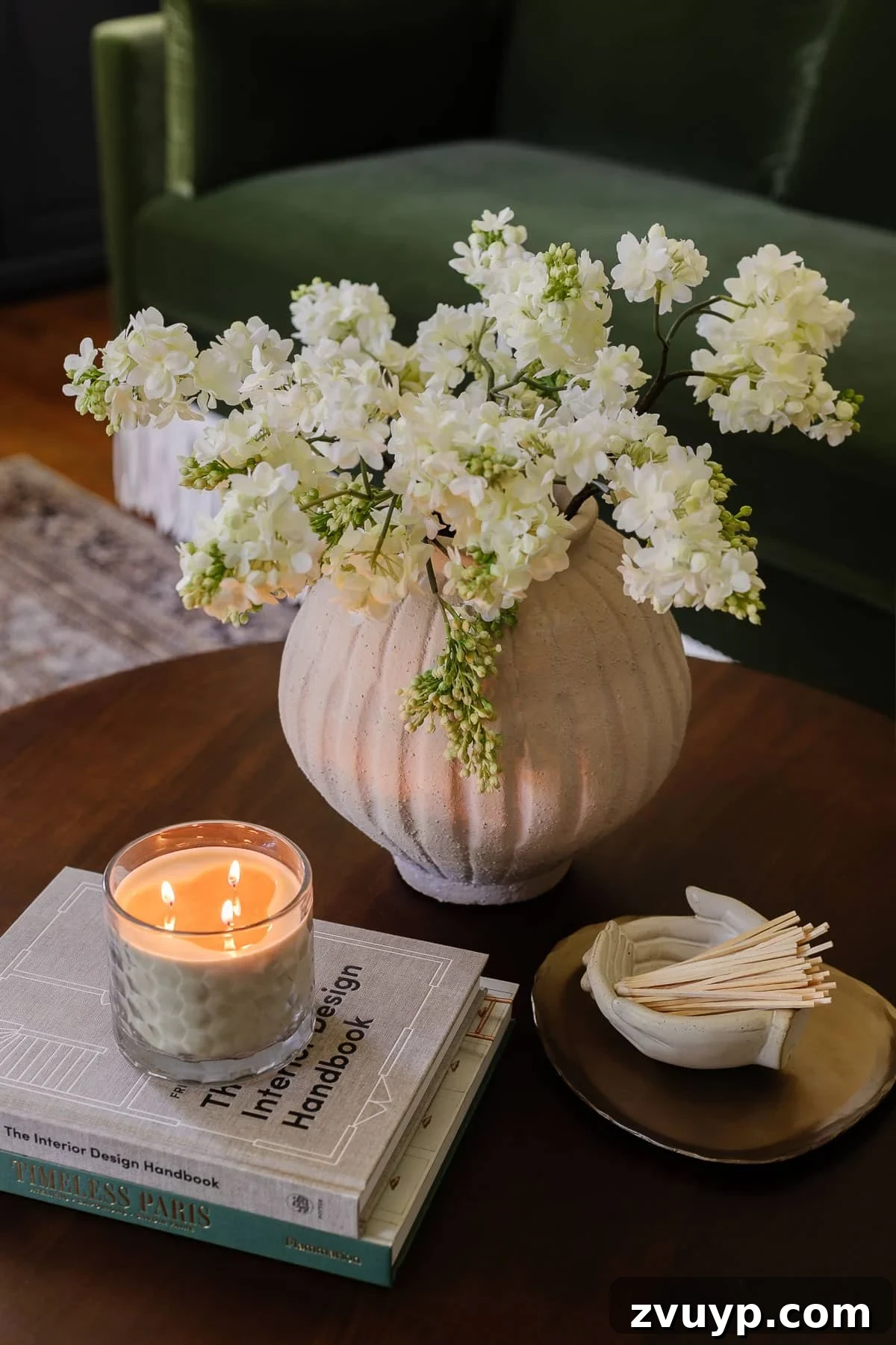Power Up Your Productivity: Smart Home Office Layouts 12 Elevated coffee table decor showcasing a beautiful vase of flowers, curated coffee table books, a scented candle, a stylish tray, and a decorative bowl of matches.