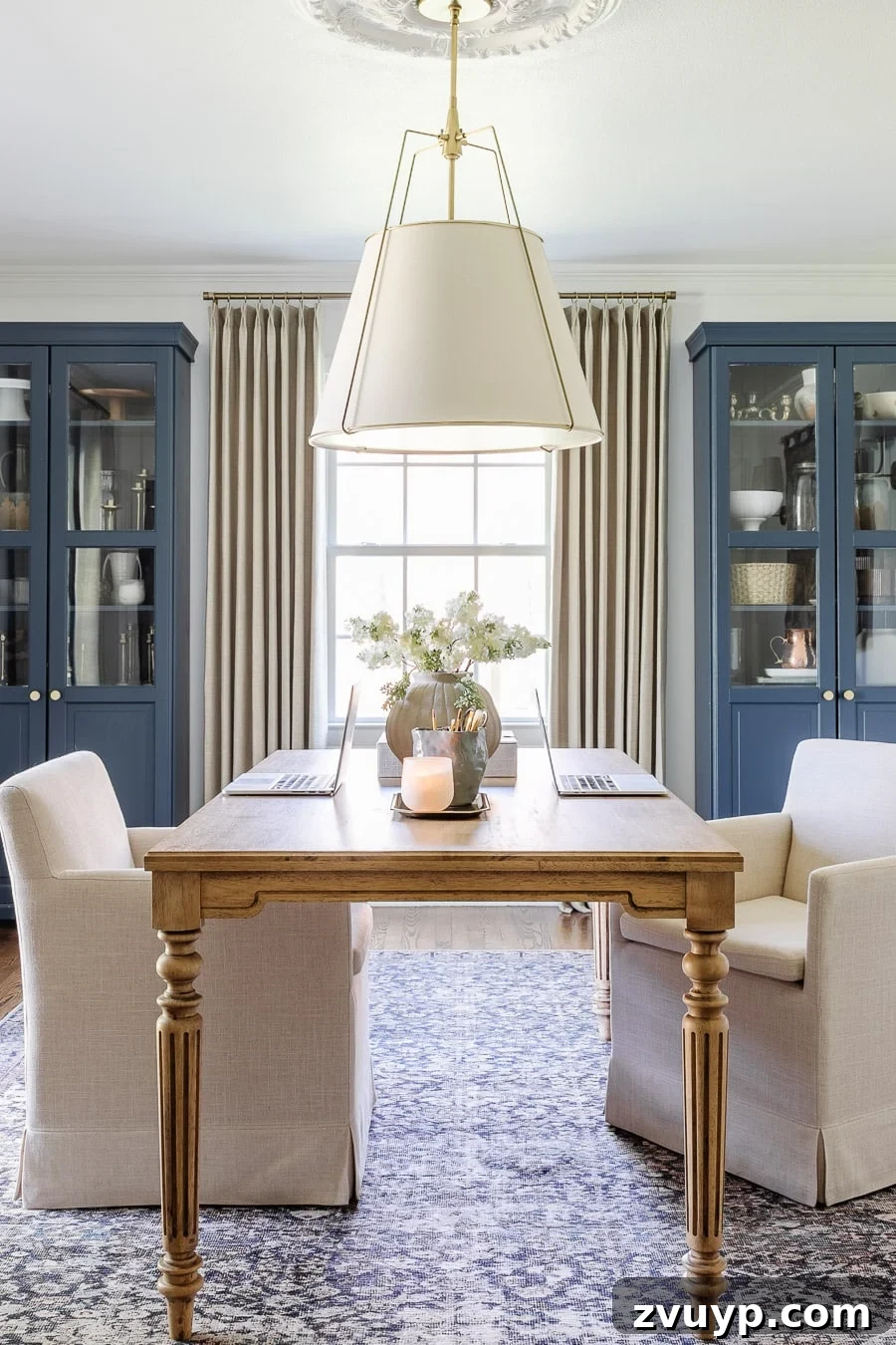 Power Up Your Productivity: Smart Home Office Layouts 3 Modern traditional home office layout for two with a large work table and comfortable rolling chairs, promoting collaboration.