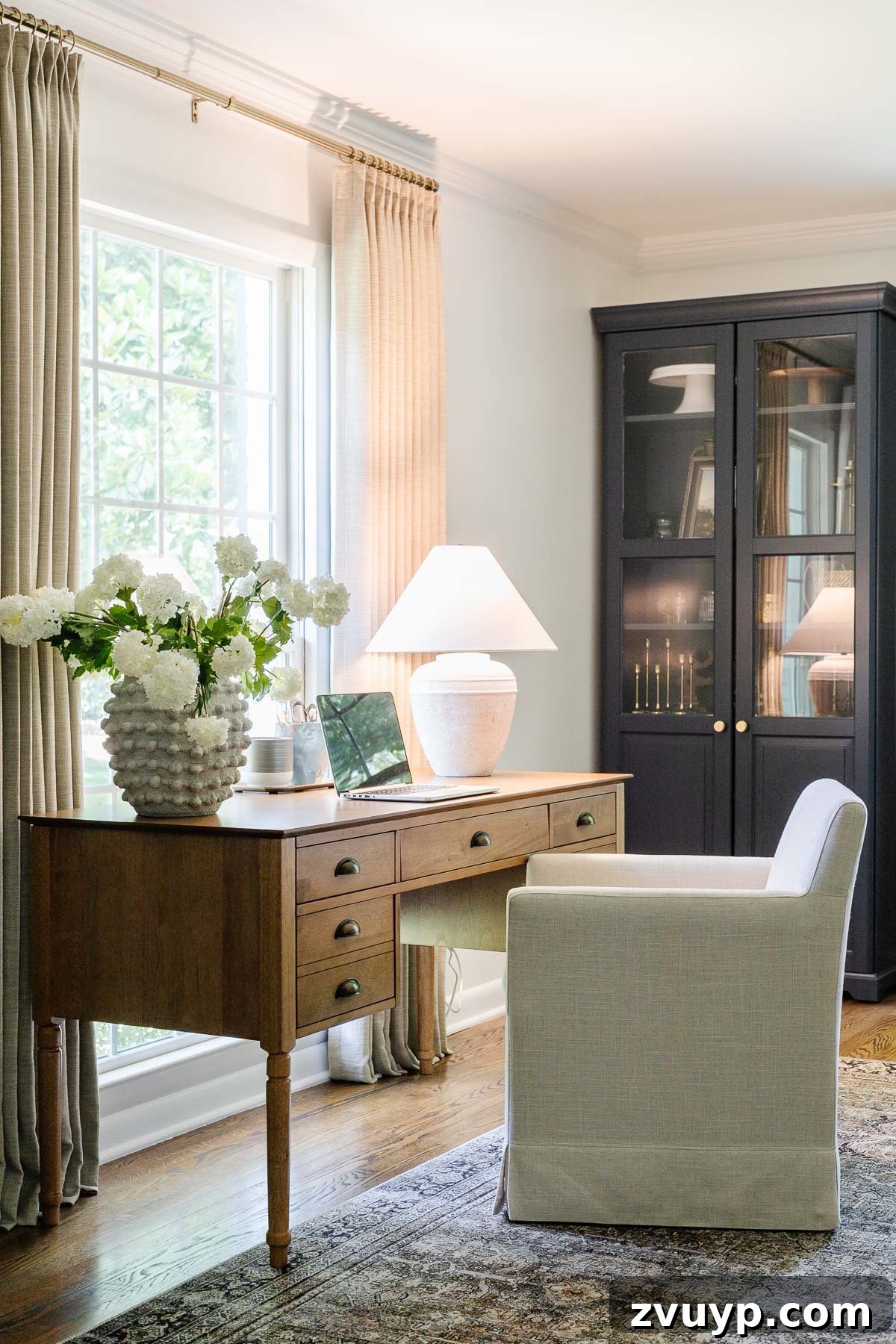 Power Up Your Productivity: Smart Home Office Layouts 6 Home office desk setup facing a window, complemented by a stylish table lamp, designed for enhanced focus and productivity.