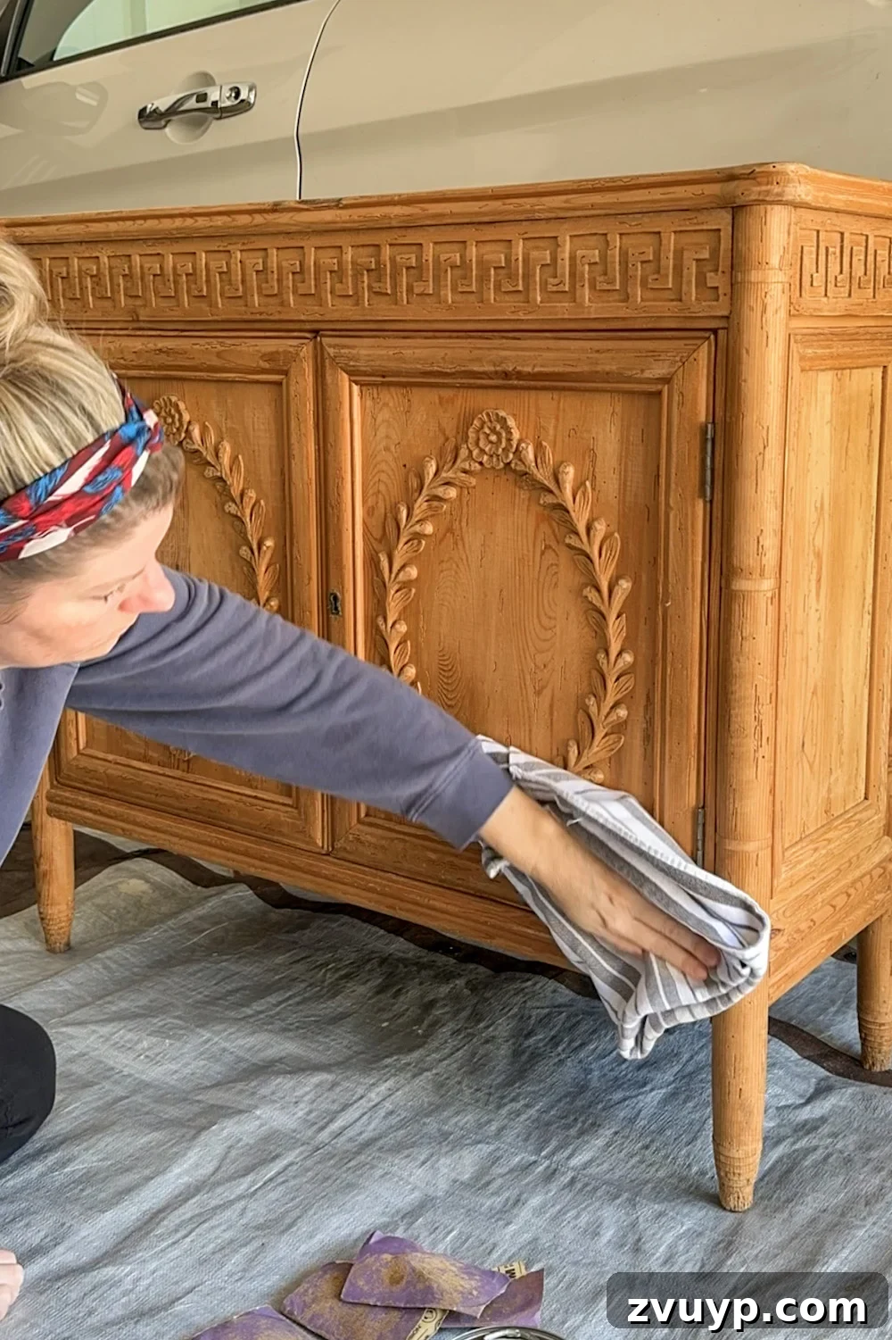 No-Sand Furniture Transformation: Stain Over Stain 6 Removing sanding dust from wood cabinet surface with a lint-free cloth