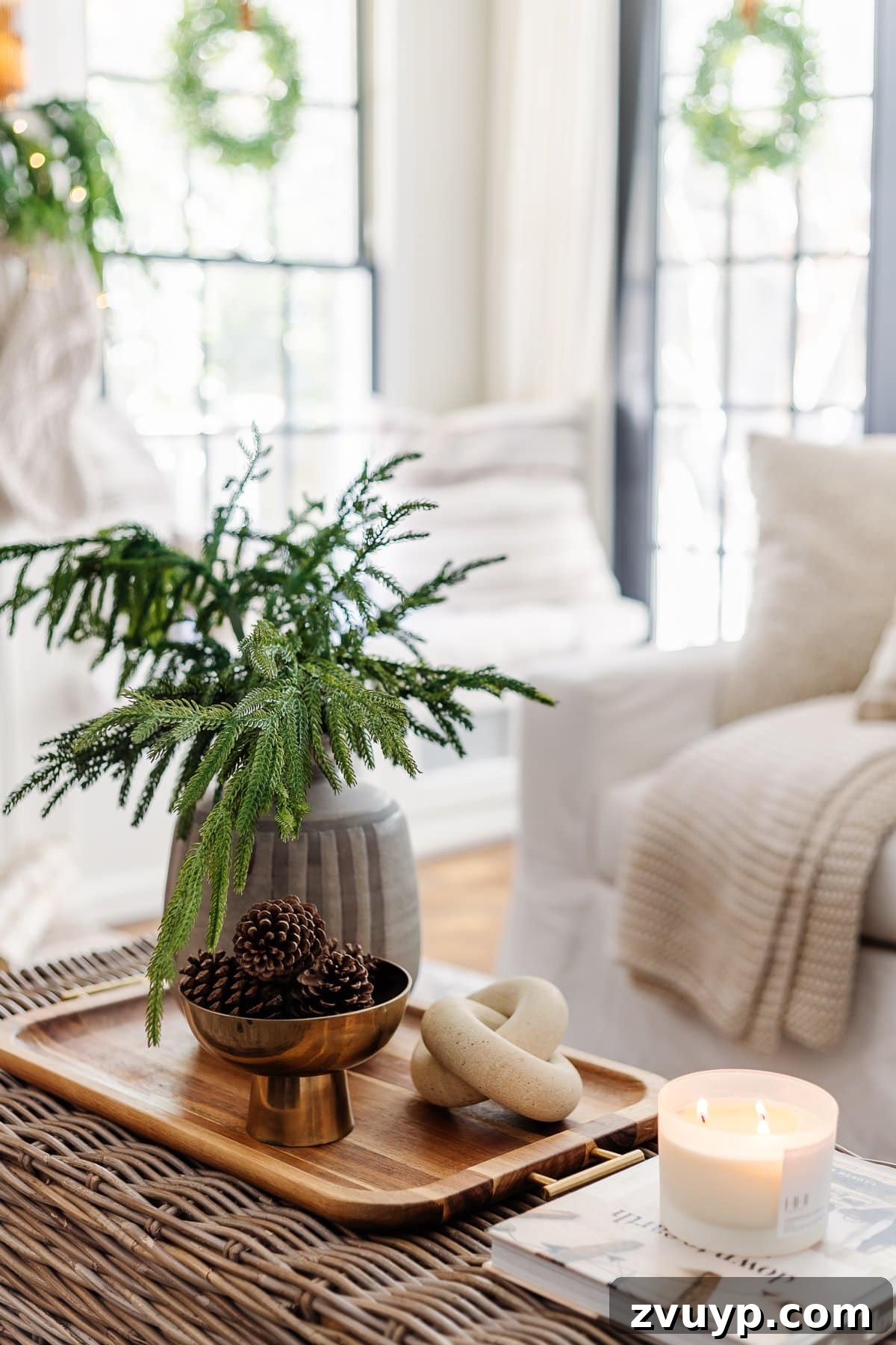 Coffee table winter decor in a living room with bowl of pinecones and vase of evergreen stems, creating a cozy atmosphere.