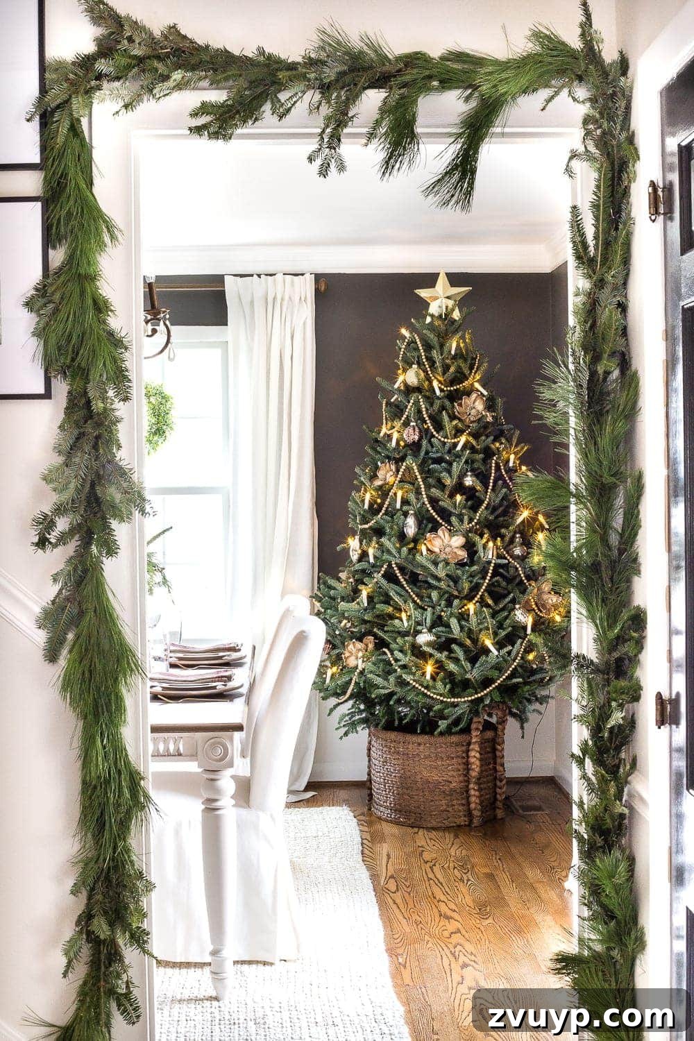 18 Charming Natural Christmas Decorations You Can Make 14 Real Christmas garland artfully displayed around a door frame, complementing a beautiful real Christmas tree for a cohesive natural look.
