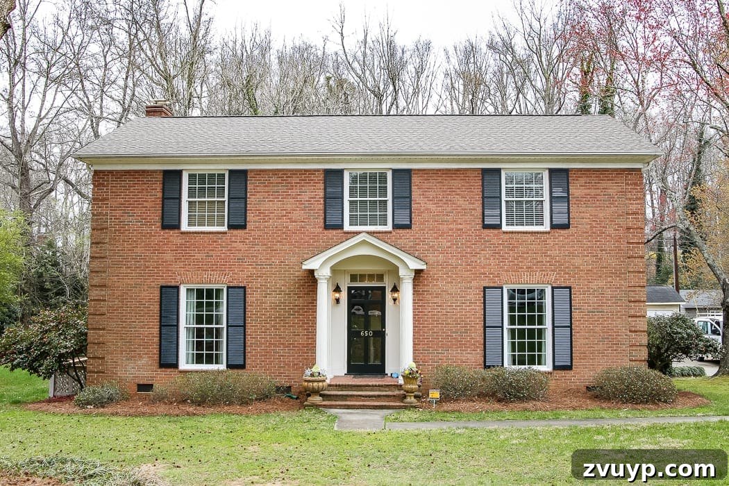 Before photo of an exterior brick colonial house with dated elements.