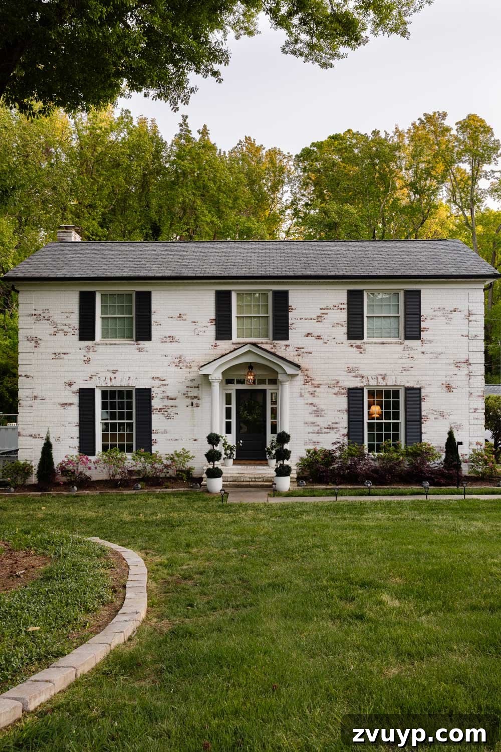 After photo showcasing a brick colonial with a new designer shingle roof replacement, enhancing curb appeal.