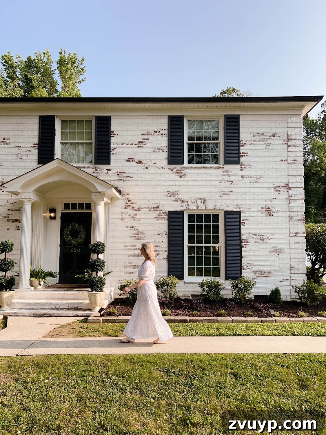 Beautifully limewashed brick colonial home in Romabio Bianco White, showcasing texture.