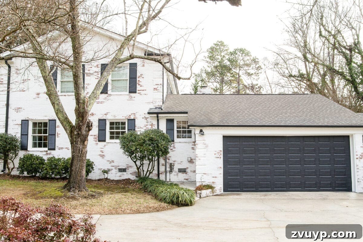 Newly painted garage door in Behr Cracked Pepper complementing a limewashed brick house.