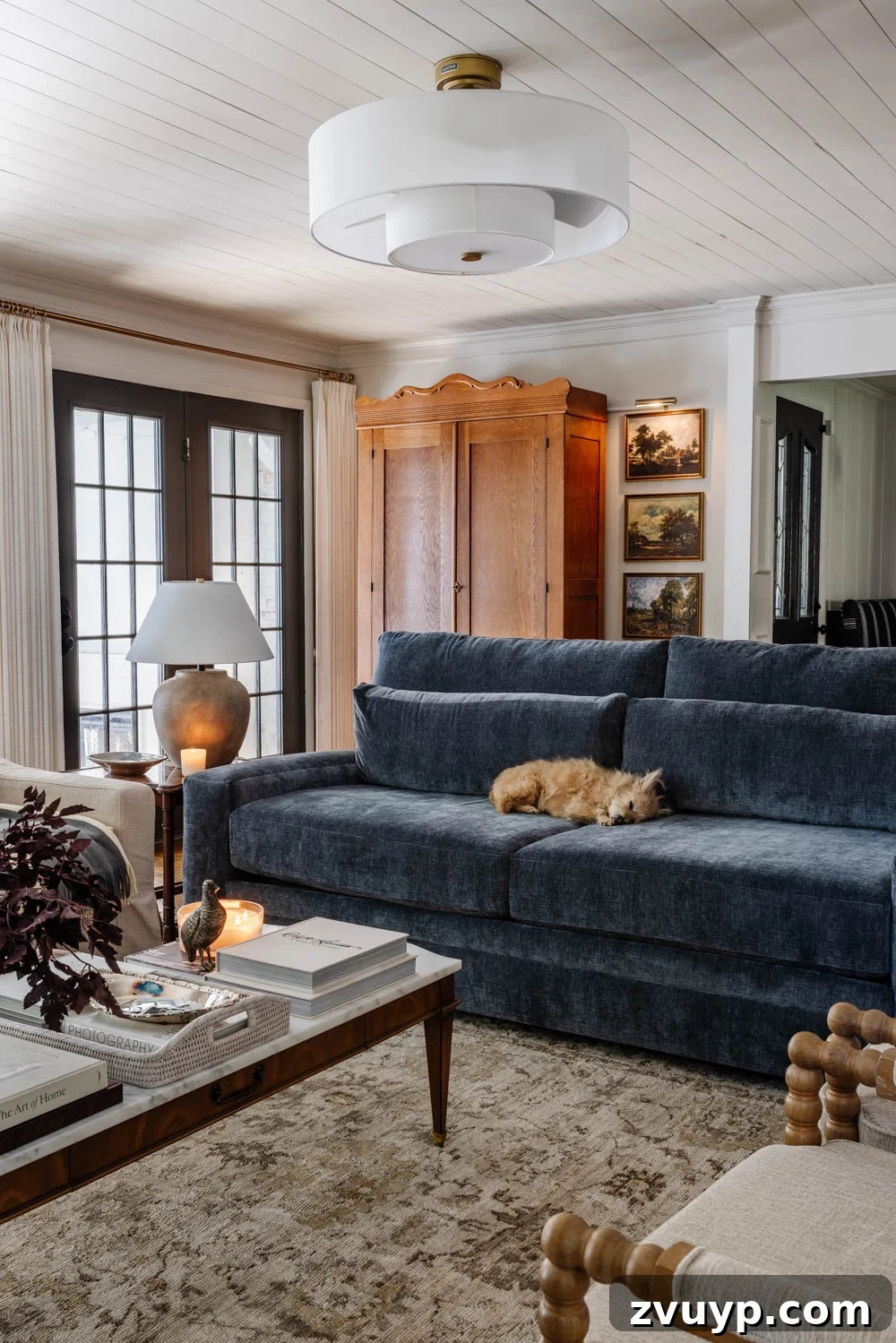 Eight Years Shaping Our Living Room 10 Cozy living room featuring a blue sofa, armoire mudroom, and newly installed tongue-and-groove ceiling