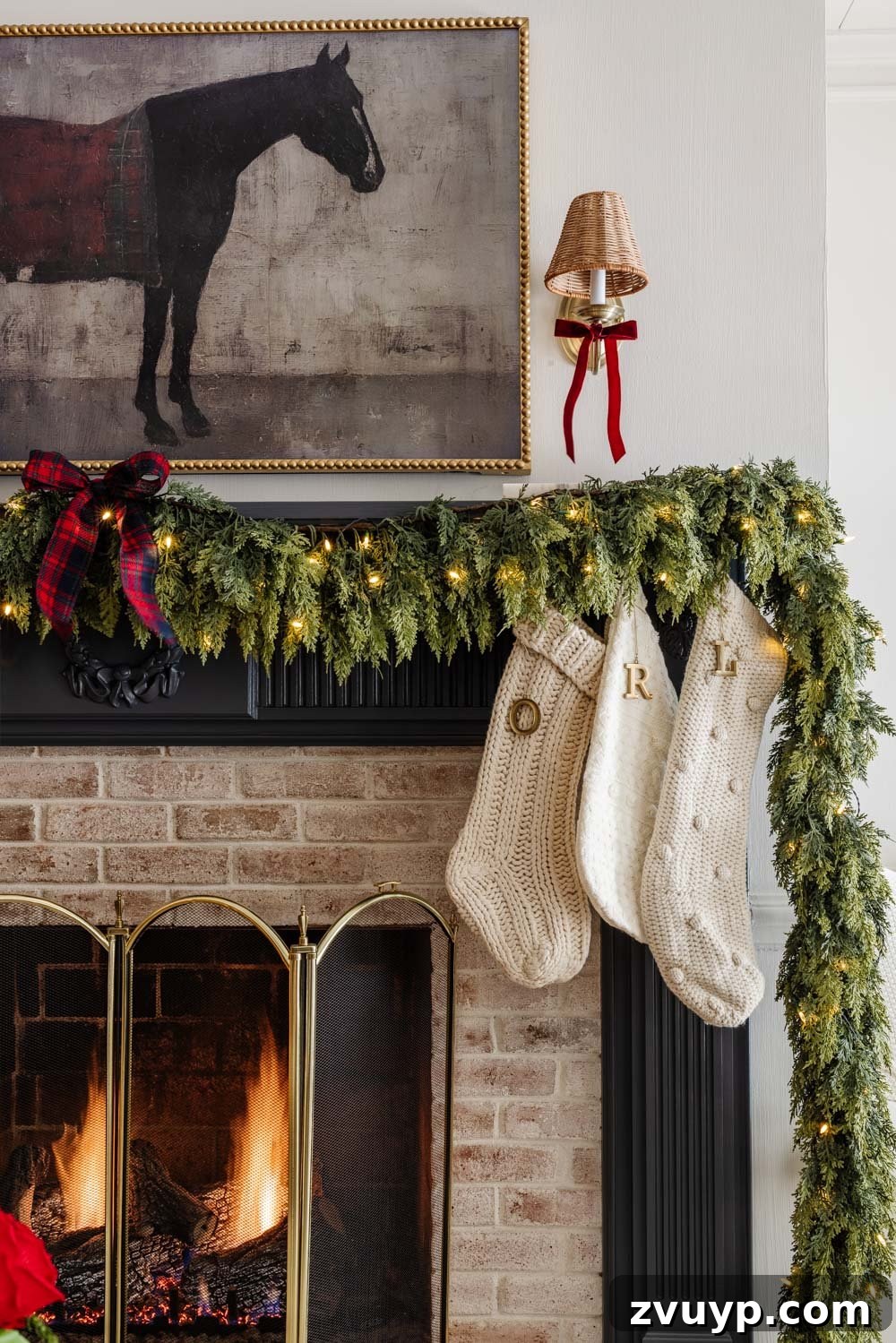 Achieving Ralph Lauren Christmas Elegance on a Dime 5 Ralph Lauren Christmas decorating ideas on a budget - navy blue mantel with garland adorned with tartan plaid ribbon
