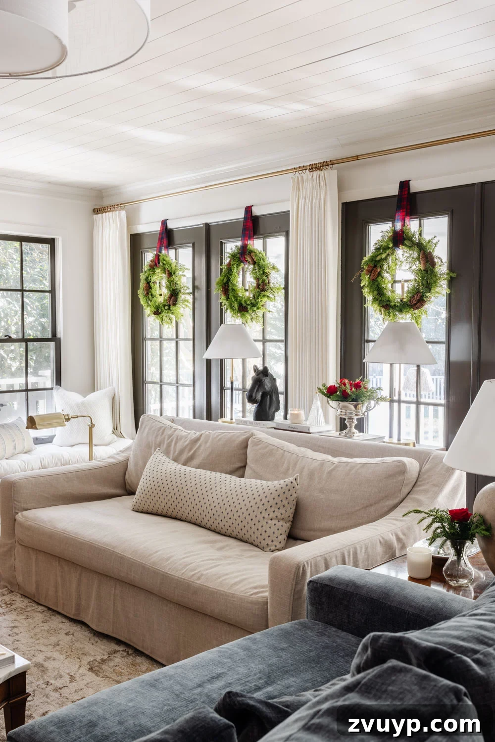 Achieving Ralph Lauren Christmas Elegance on a Dime 8 Ralph Lauren Christmas decorating ideas on a budget - wreaths with tartan plaid ribbon on windows, glowing with soft light