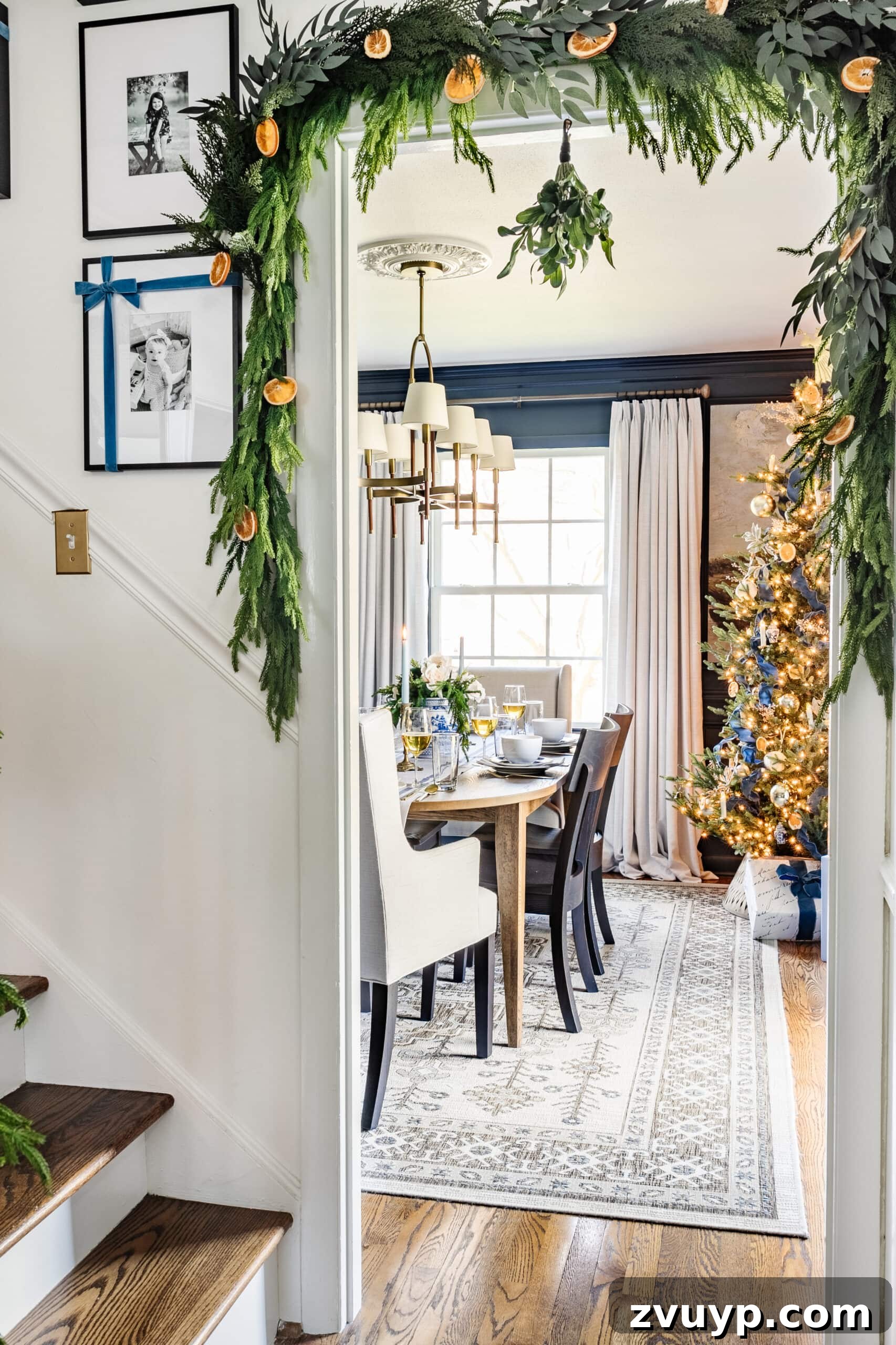Hang Garland Over Any Doorway Damage-Free and Custom 19 Lush doorway garland with red ribbon and dried oranges for a festive Christmas entryway.