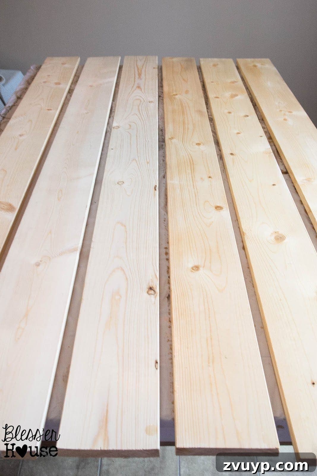 Simple Vinegar and Steel Wool Wood Stain Recipe 7 A side-by-side comparison shows regular lumber next to planks treated with black tea stain (on the left), highlighting the subtle darkening and tannin enhancement.