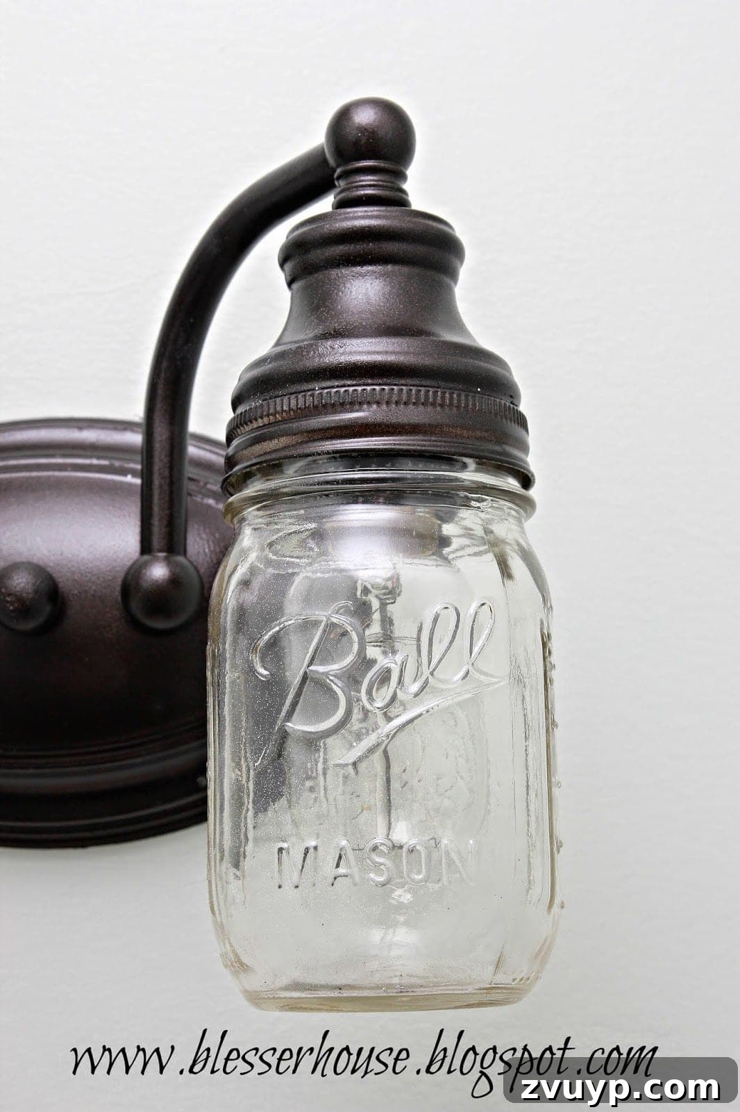 Finished DIY farmhouse mason jar vanity light with Edison bulbs, illuminated