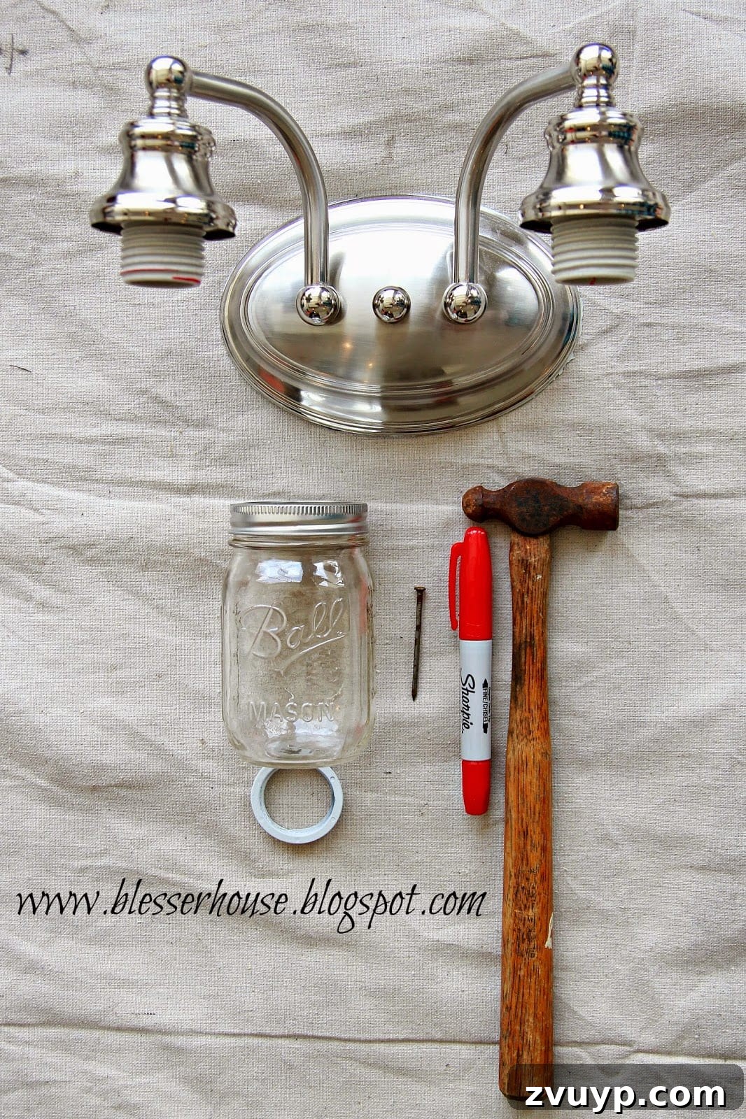 Original builder-grade bathroom vanity light fixture disassembled, ready for spray painting
