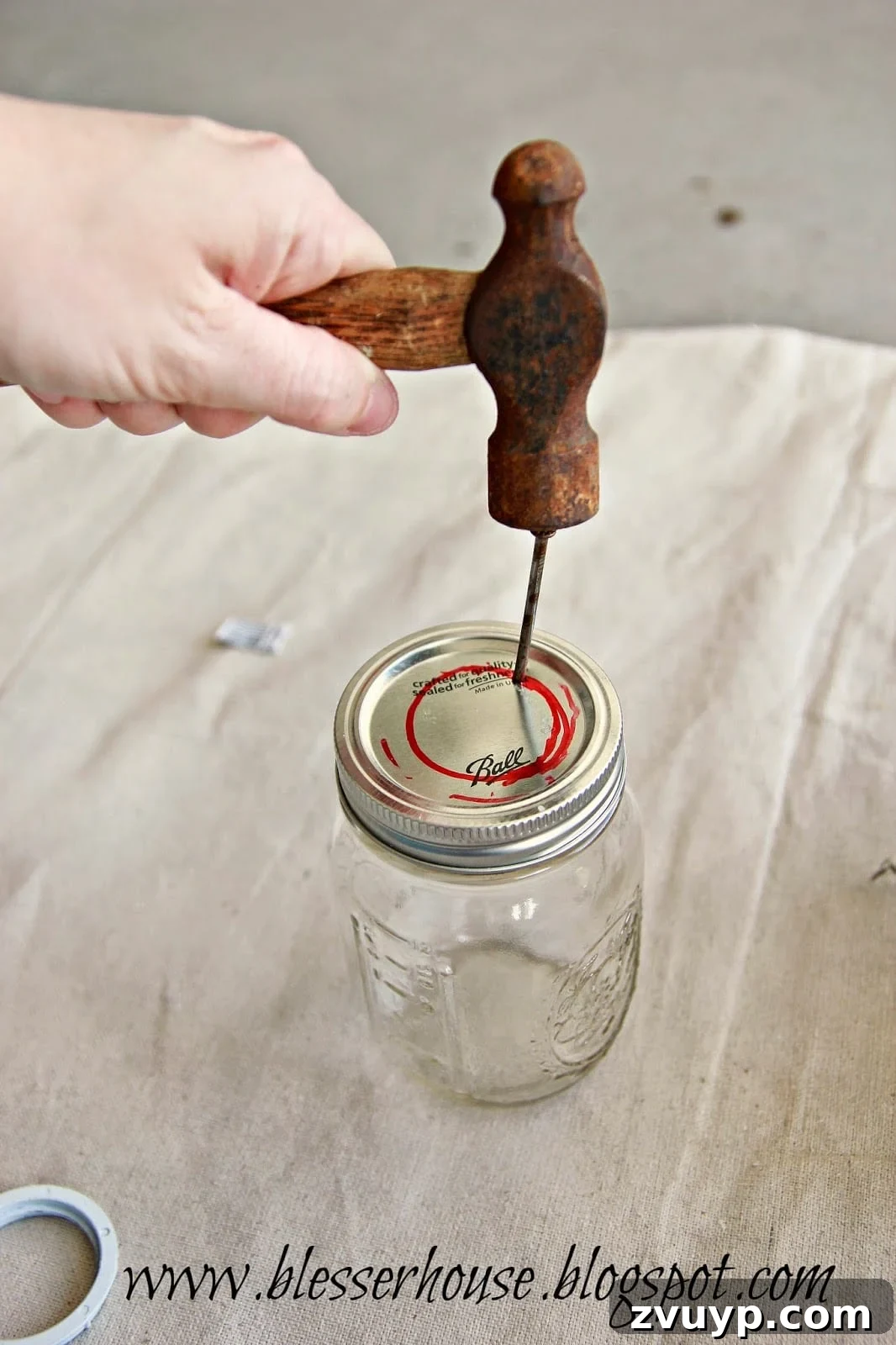 Nailing holes around the traced circle on a mason jar lid