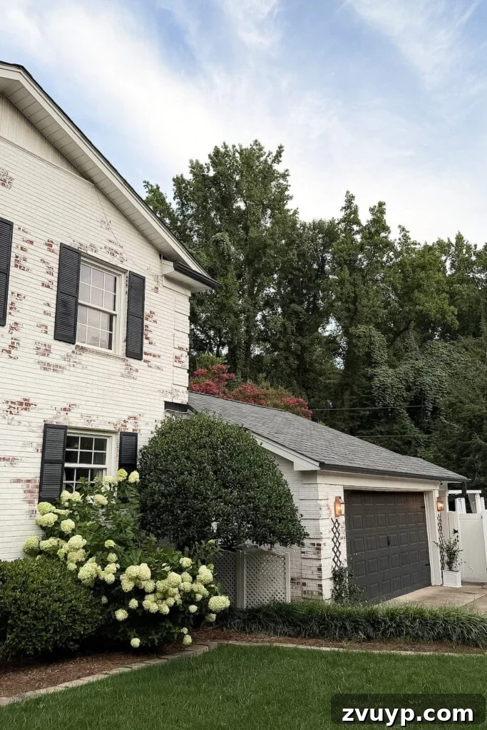 garage curb appeal with copper lanterns, star jasmine, and outdoor trash can hiding panels