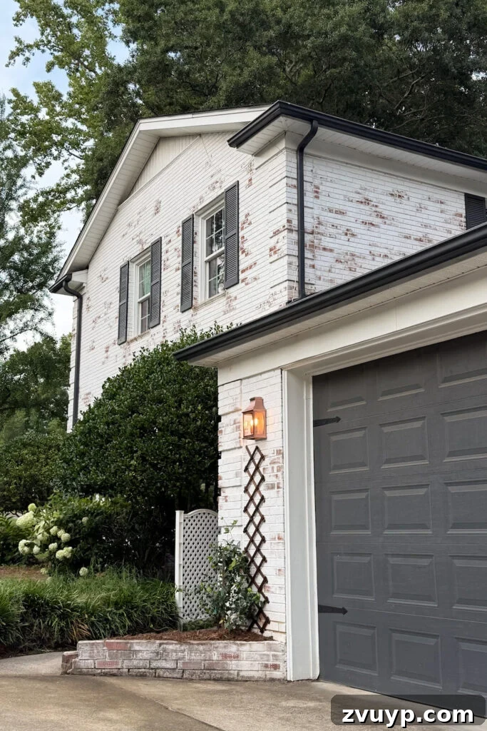 garage curb appeal with copper lanterns, star jasmine, and outdoor trash can hiding panels