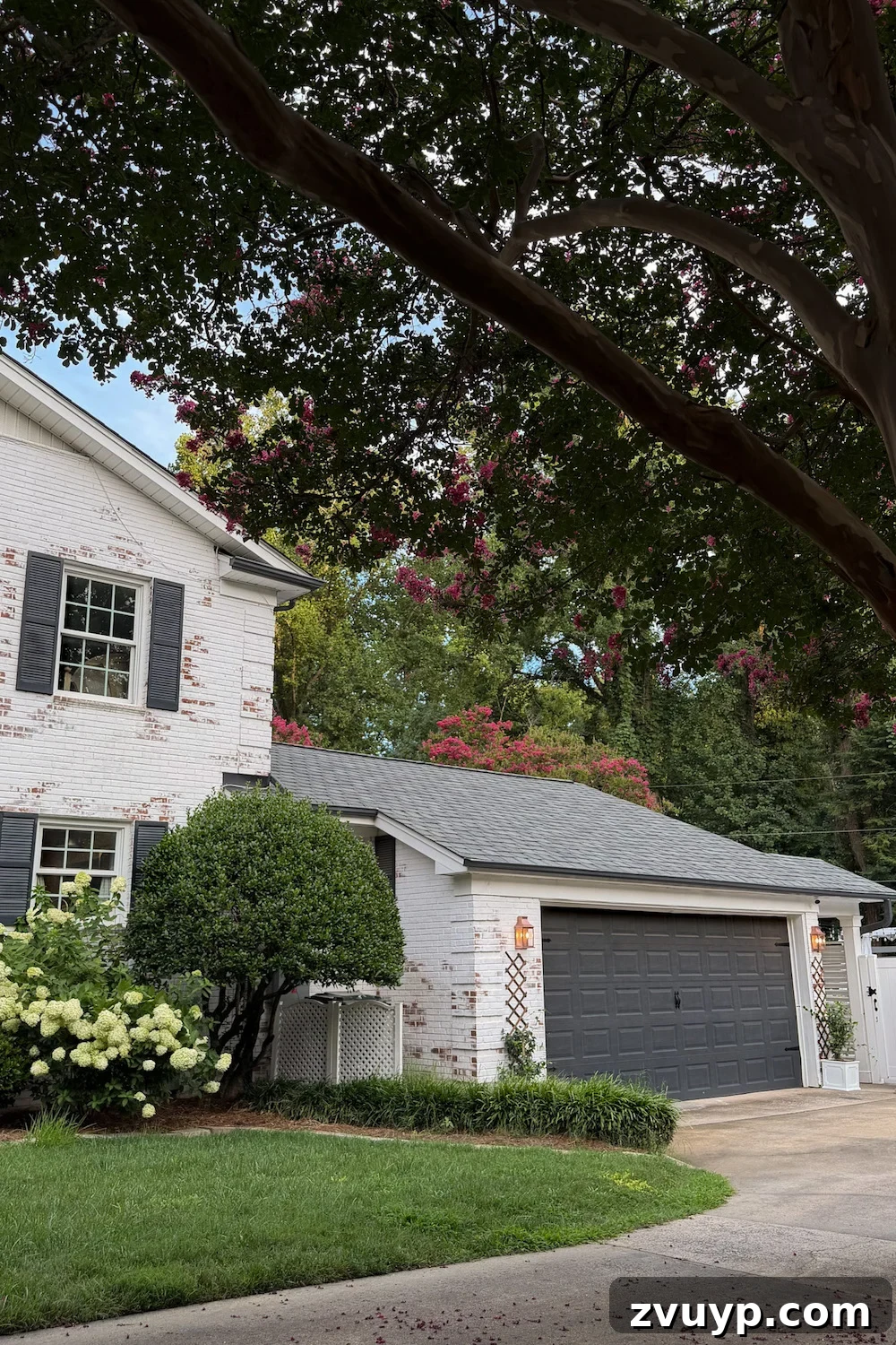 garage curb appeal with copper lanterns, star jasmine, and outdoor trash can hiding panels