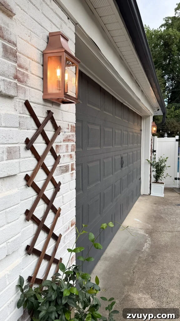 garage curb appeal with copper lanterns, star jasmine, and outdoor trash can hiding panels