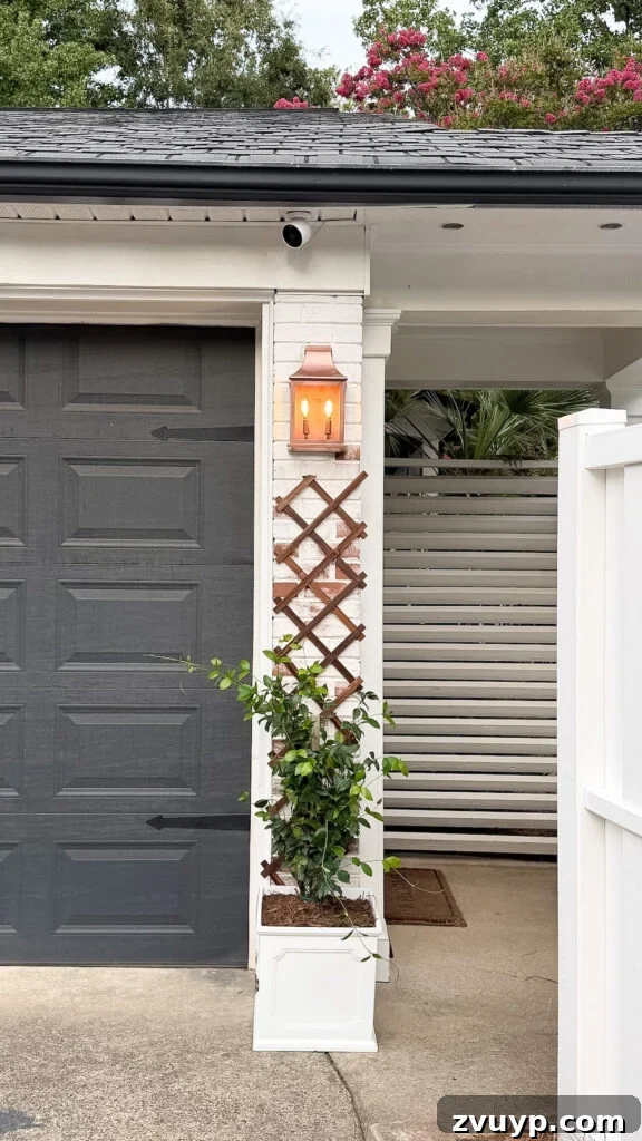 garage curb appeal with copper lanterns, star jasmine, and outdoor trash can hiding panels