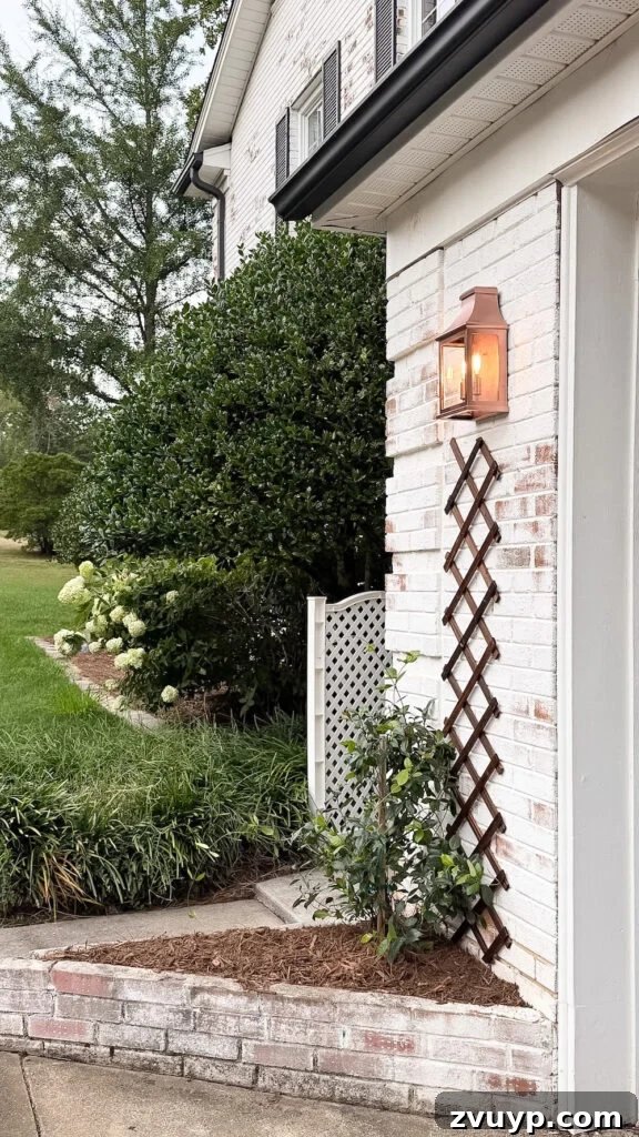 garage curb appeal with copper lanterns, star jasmine, and outdoor trash can hiding panels